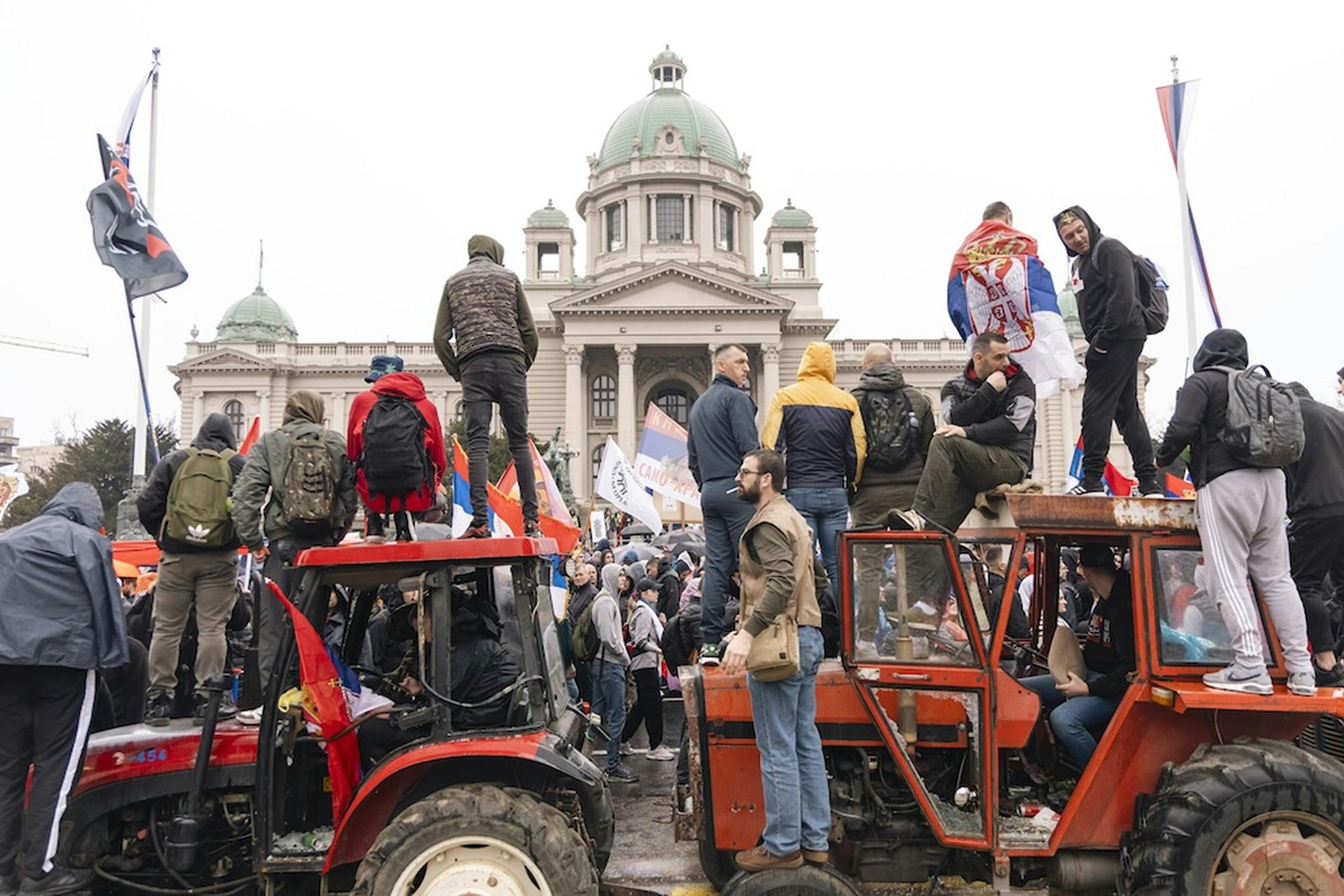 Srbski protestniki na traktorjih. V ozadju pravoslavna cerkev.