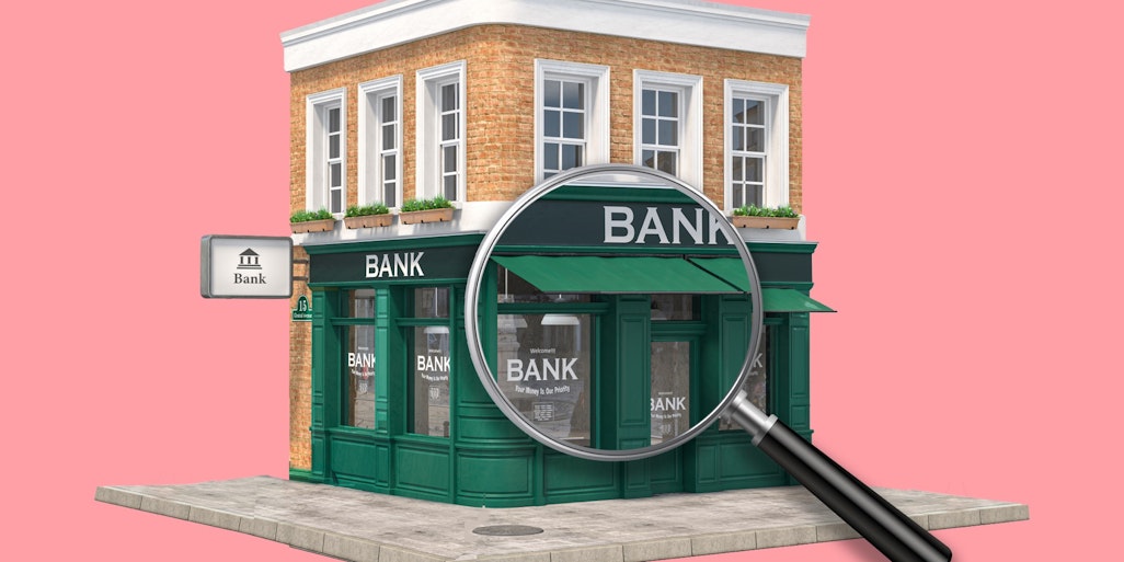 Bank building with magnifying glass | What is a merchant acquirer?