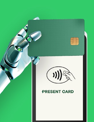 a robot hand holding a card over a payment device