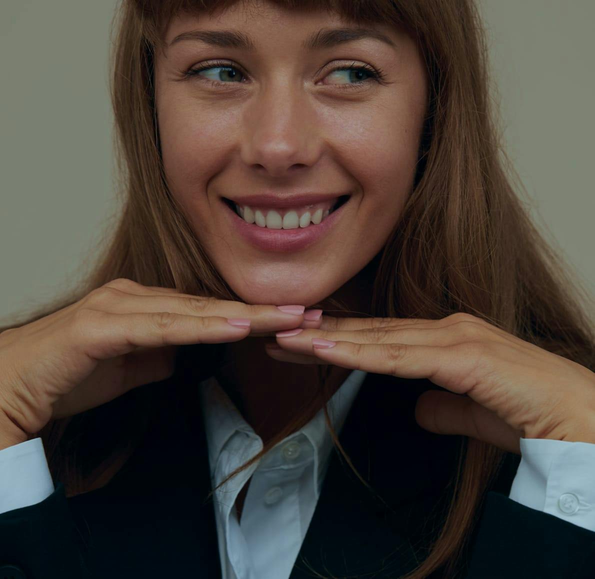 Woman smiling with chin on hands