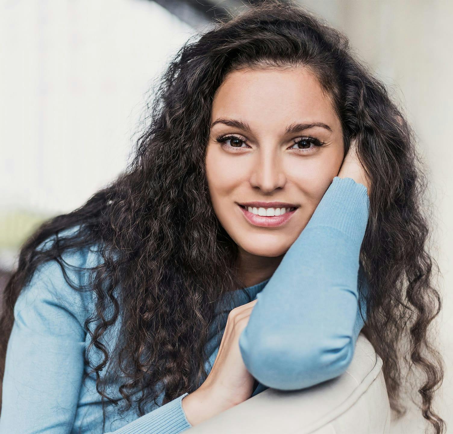 Woman smiling and resting head on arm