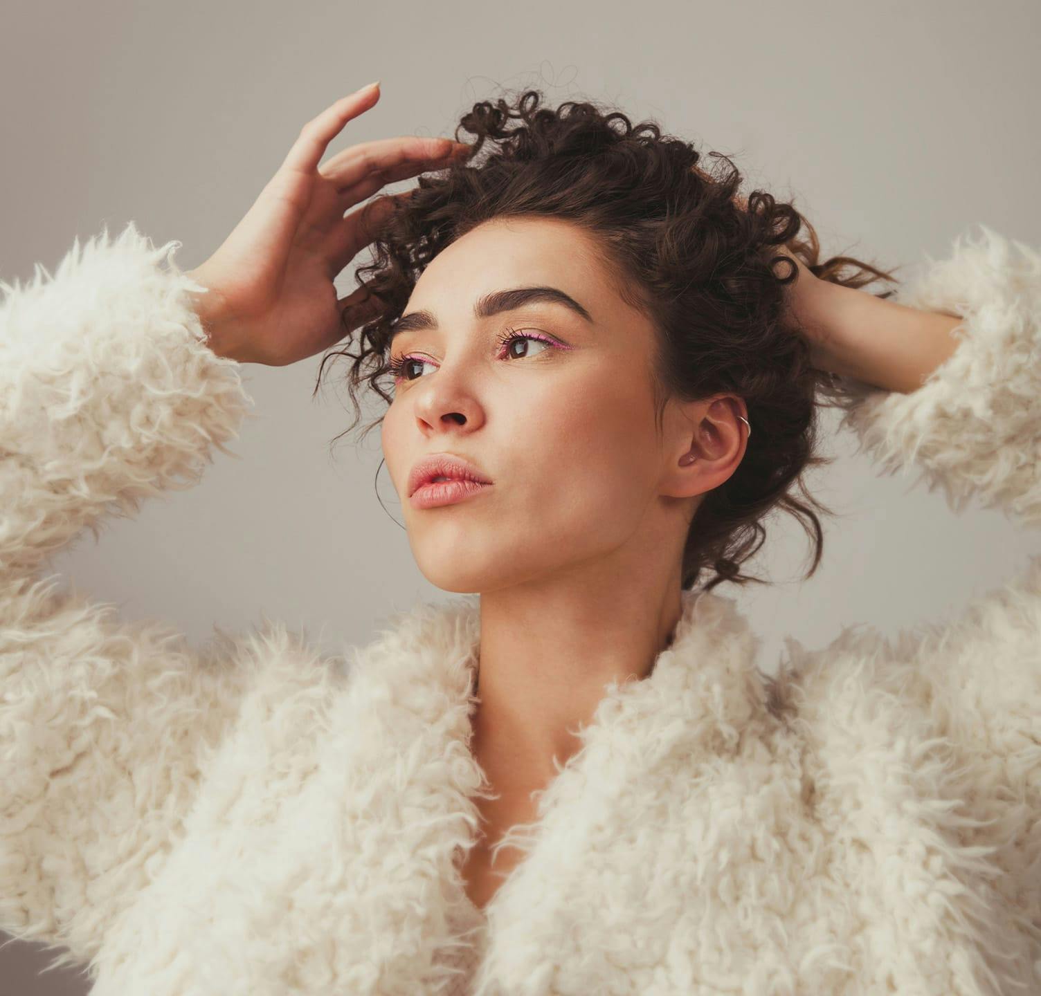 Woman wearing Fur coat adjusting her hair