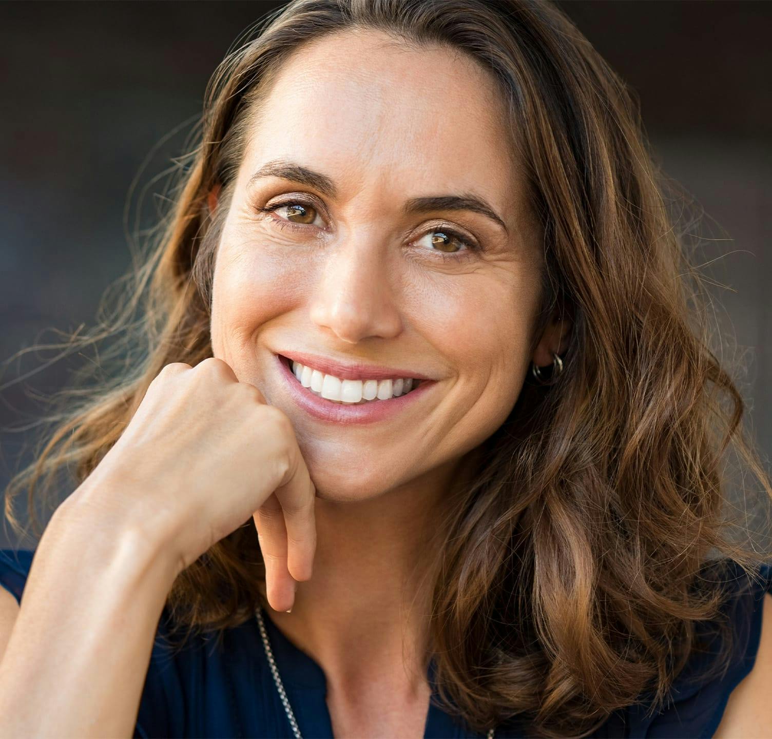 Woman smiling and resting head on chin