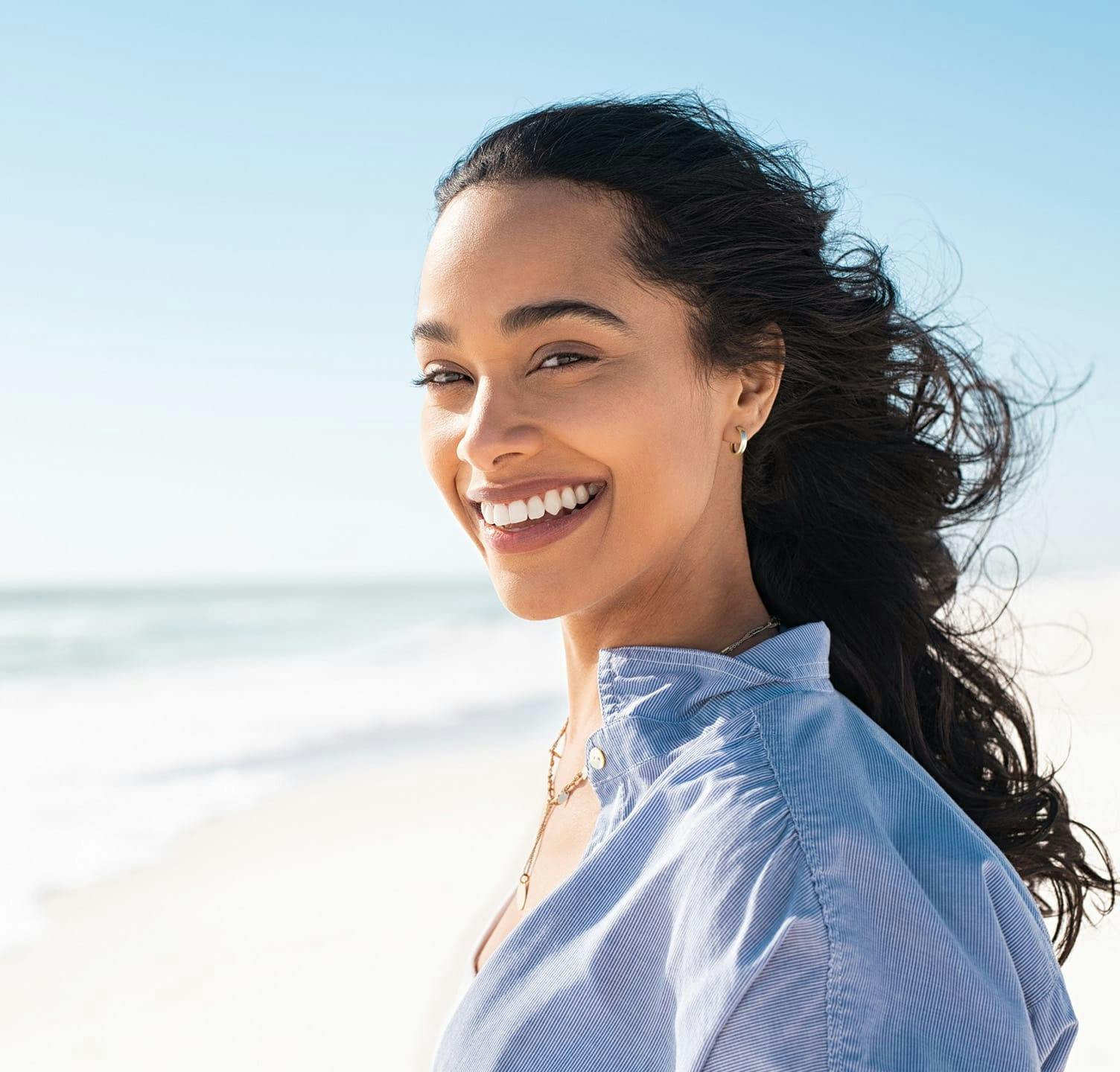 Woman smiling and standing on the beach