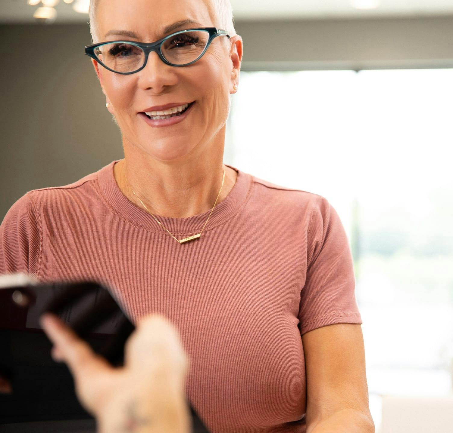 Woman smiling and grabbing clip board