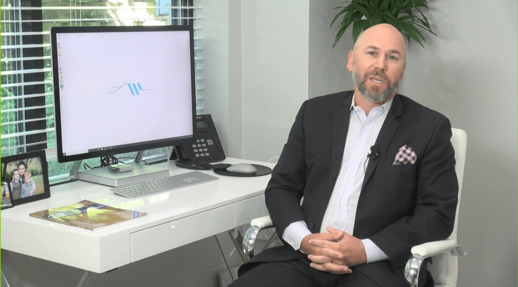 Dr. Warner sitting at desk next to computer