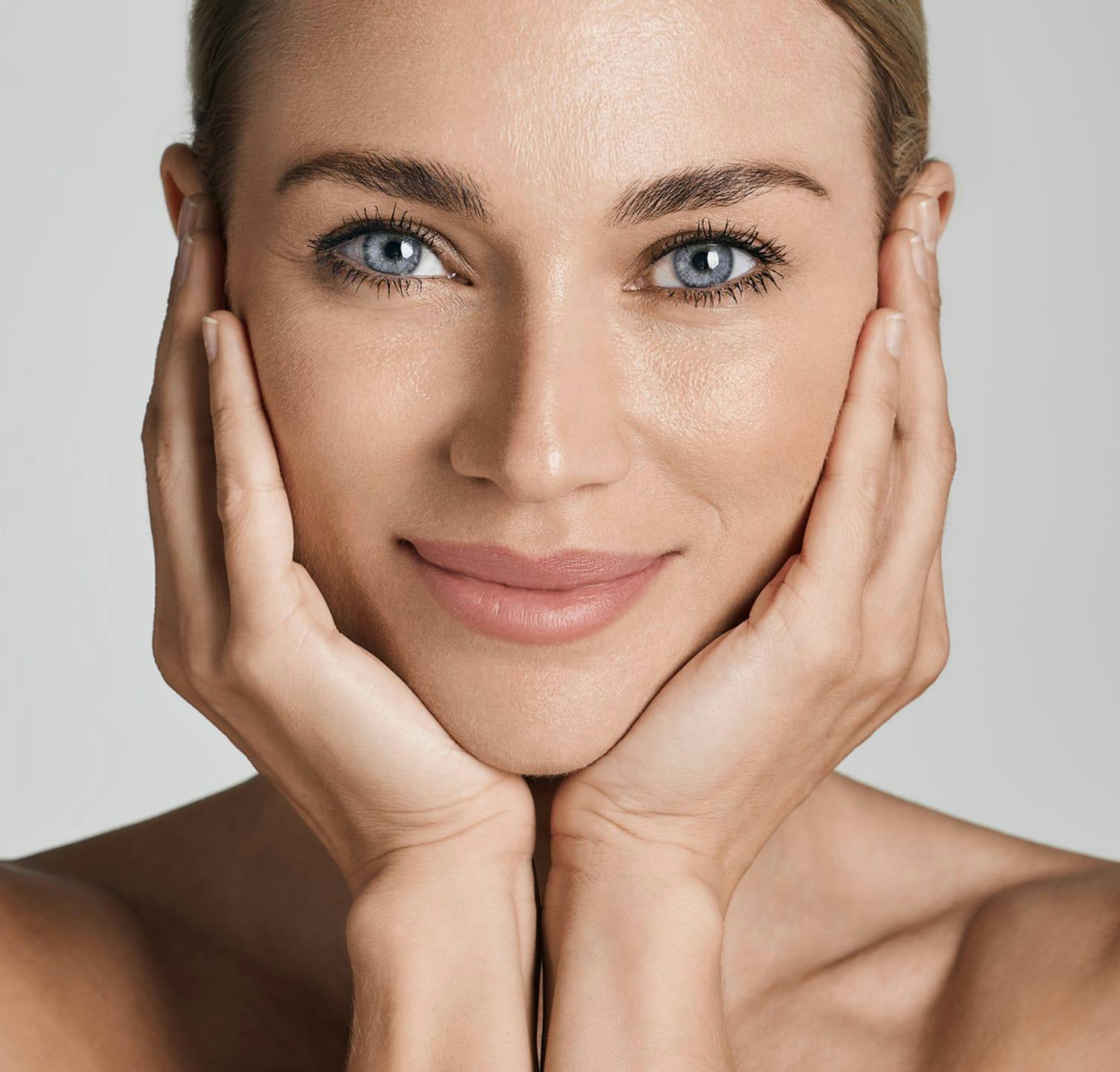 Smiling woman holding cheeks