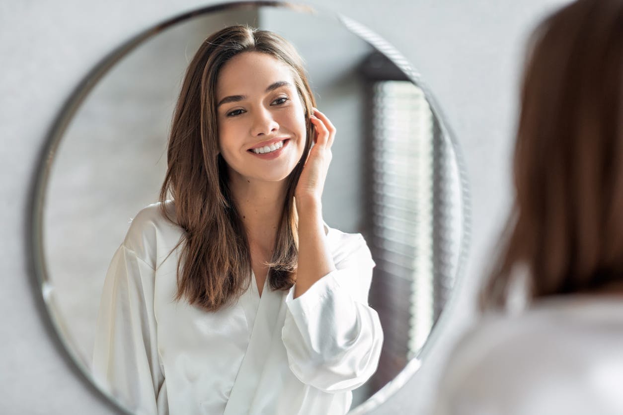 Woman smiling into mirror