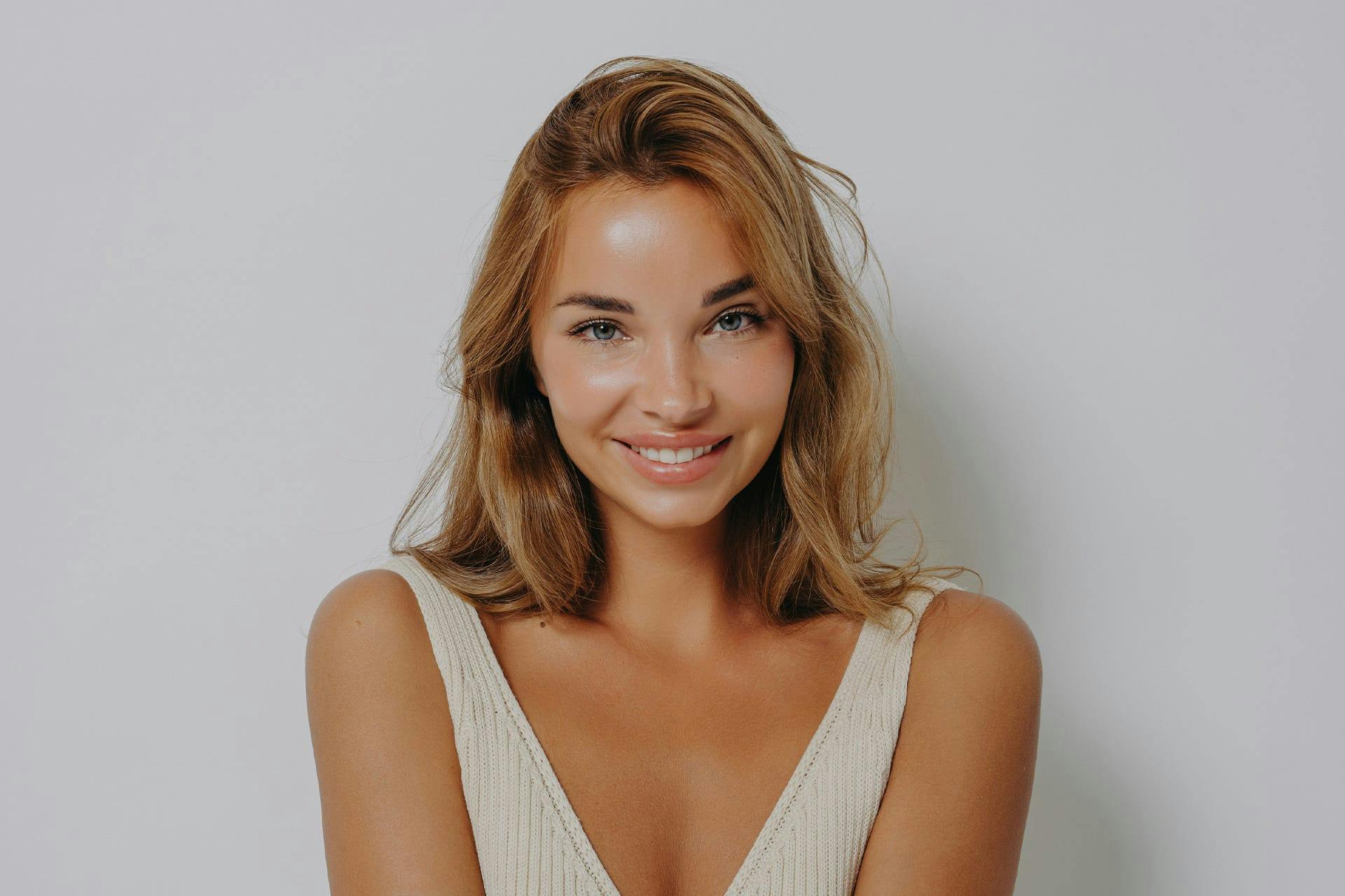 Young woman in white dress smiling at camera