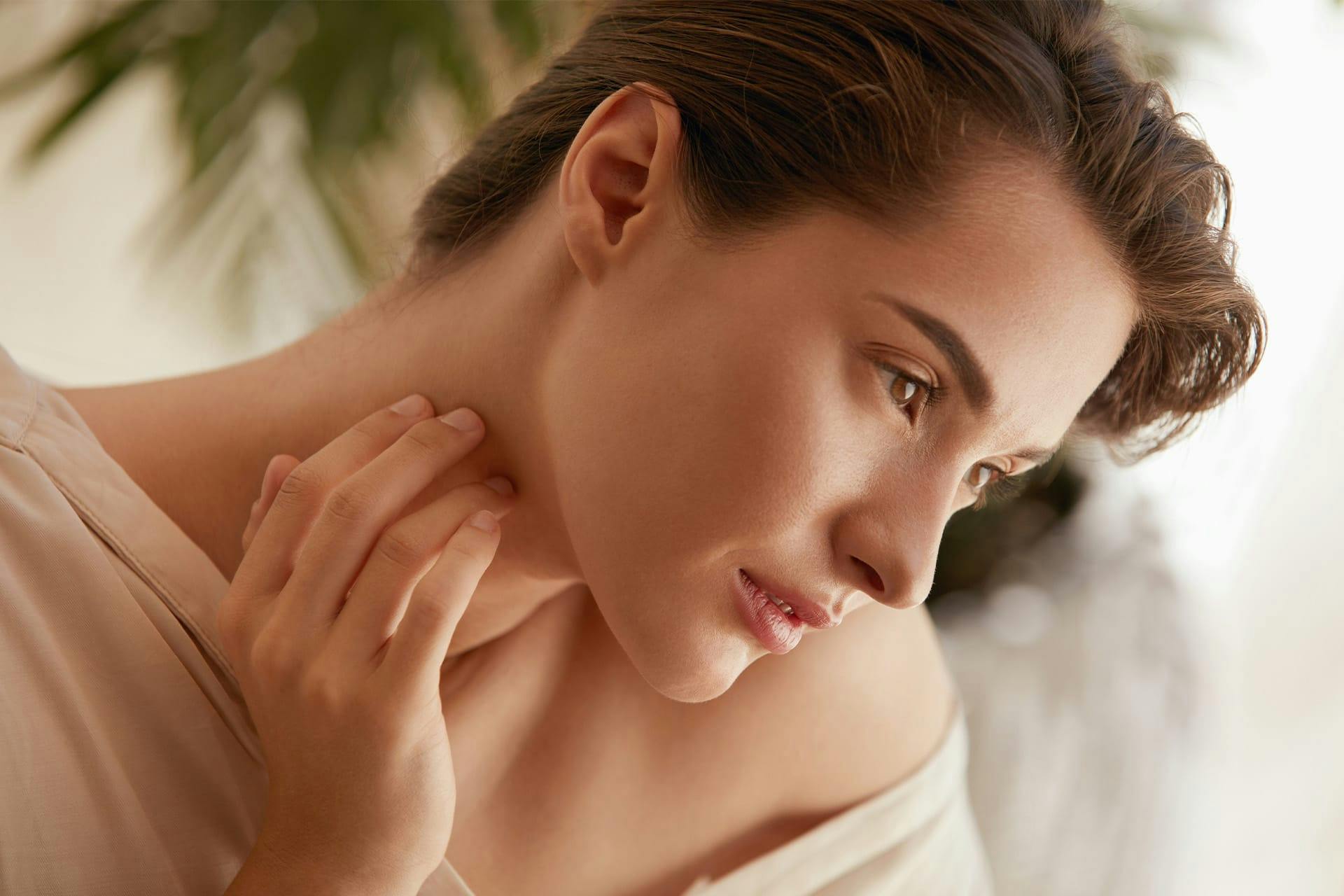Woman posing with hand on neck