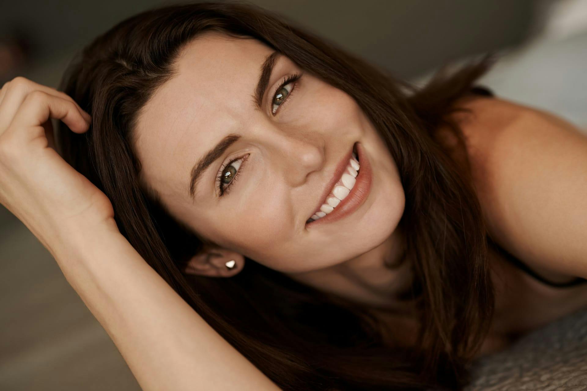 Woman smiling with head in hand