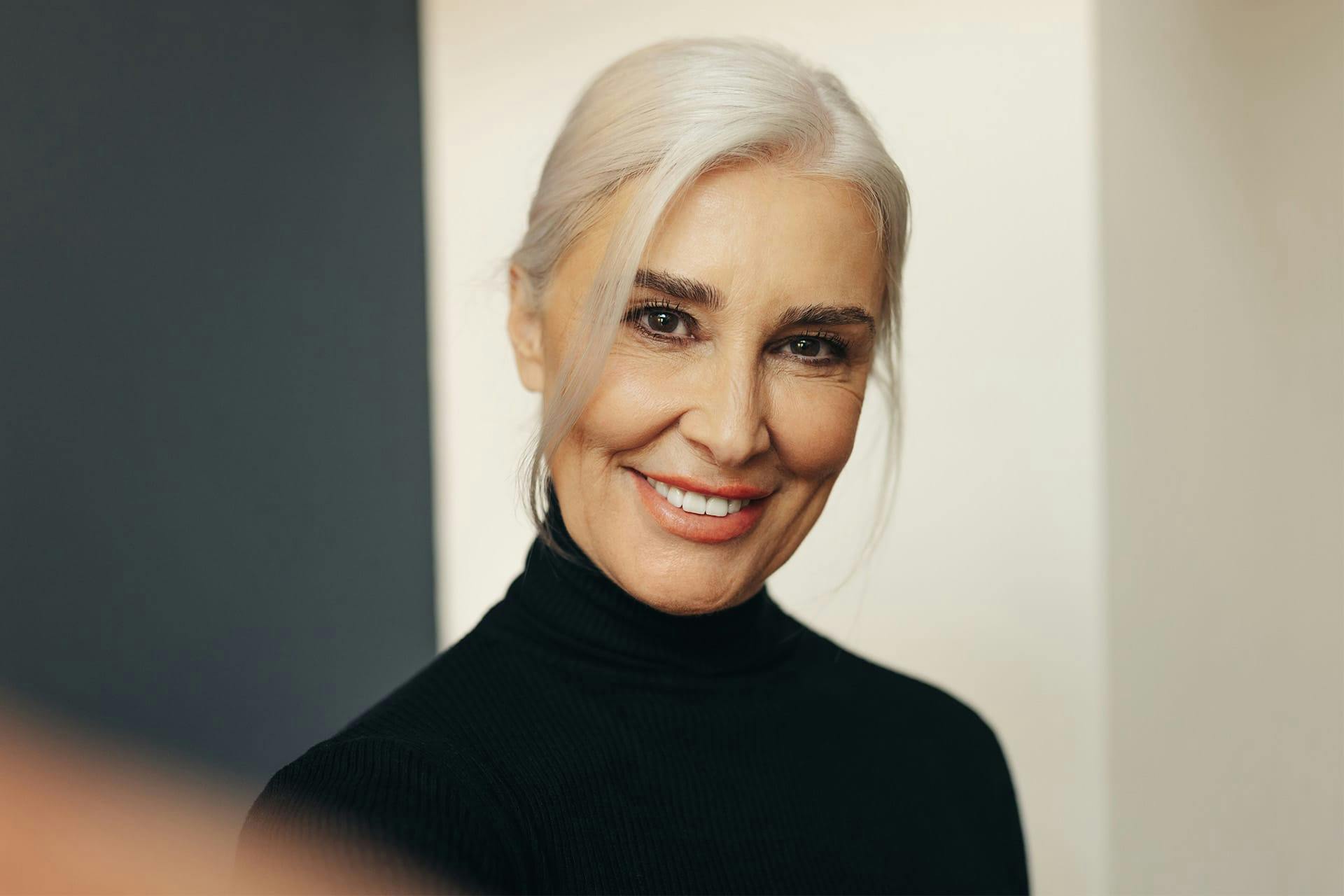 Smiling older woman in black turtleneck