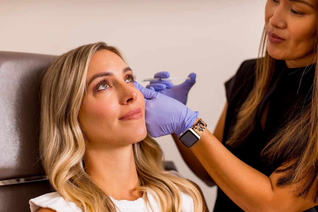 Office staff giving injection to woman