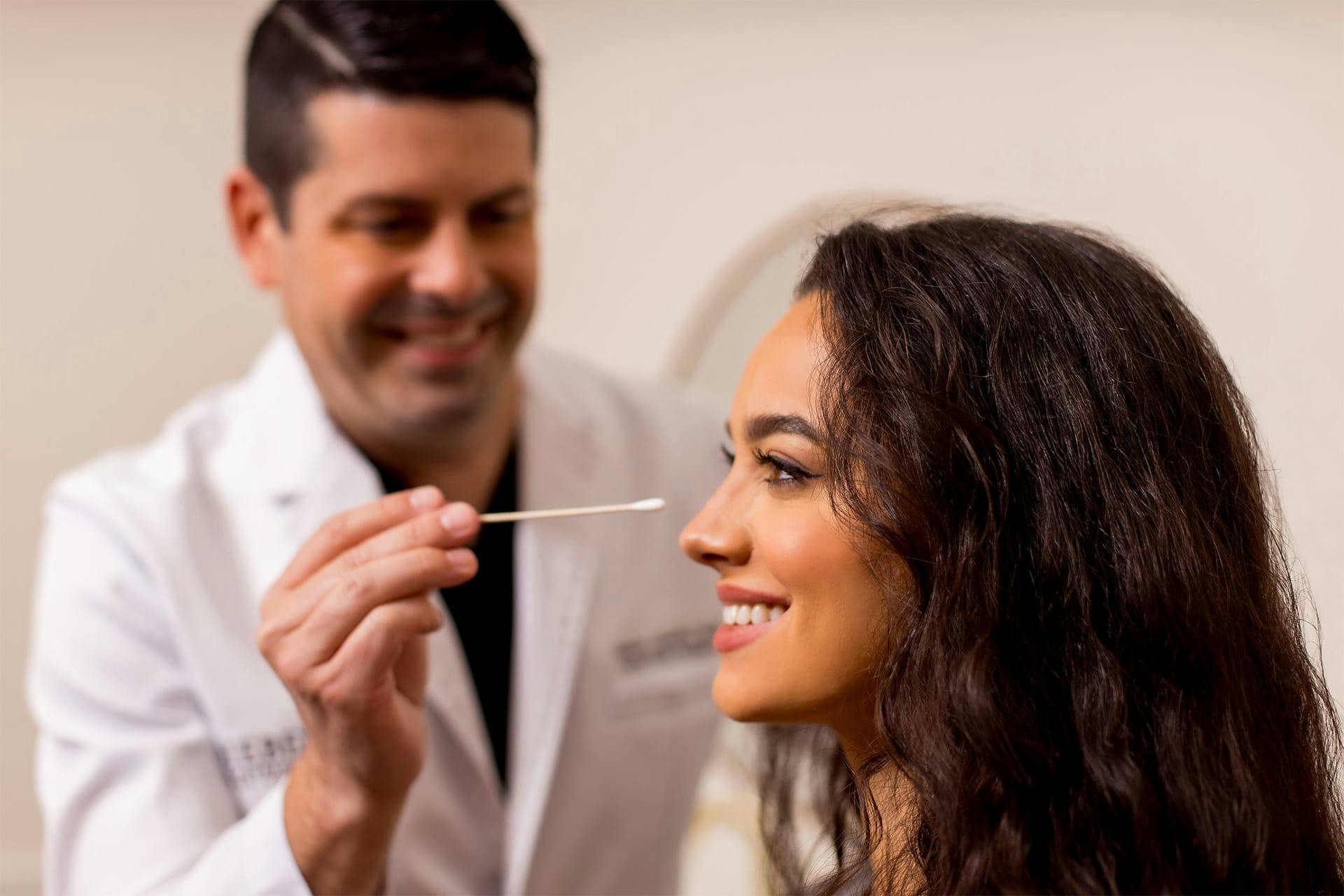 Dr. Daniel Liebertz holding swab to client's face