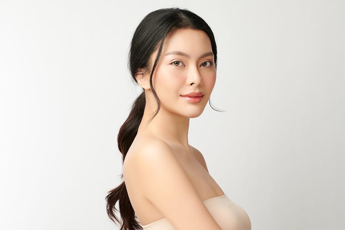 Side view of woman in strapless tan dress posing