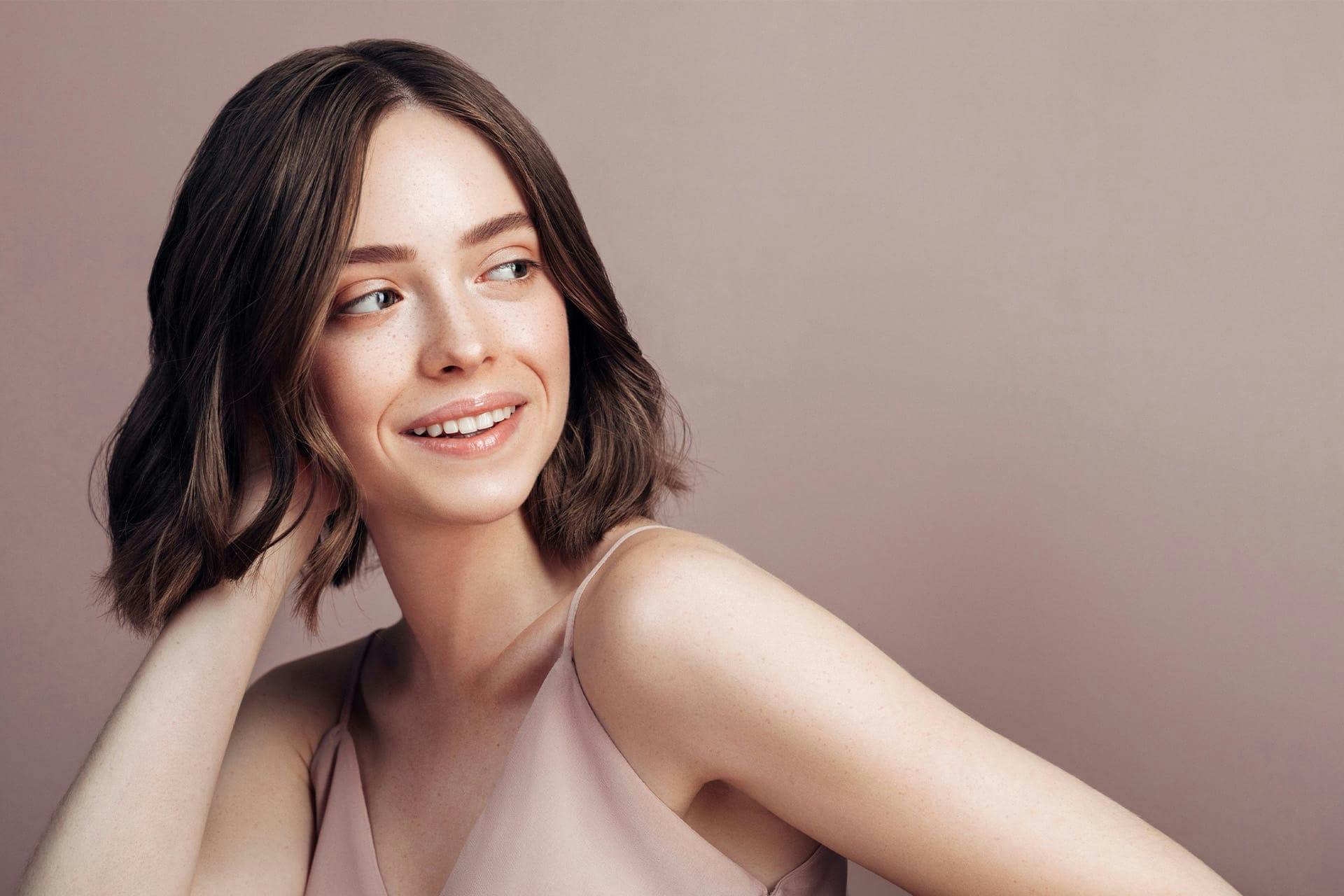 Young woman smiling with hand in hair