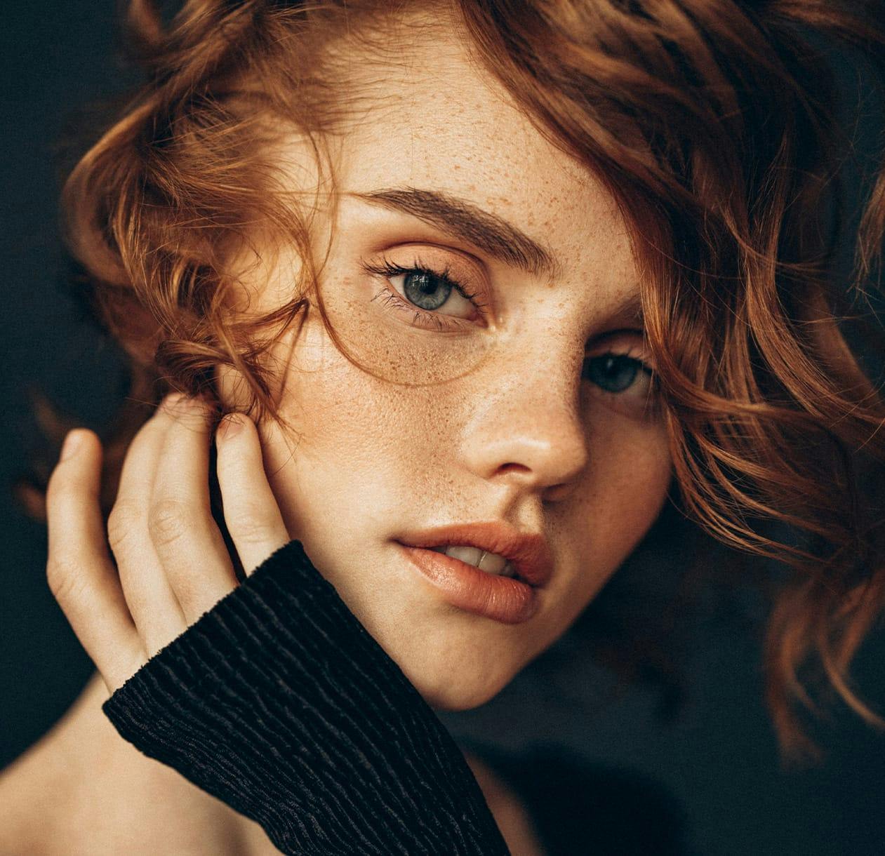A red-headed model with freckles