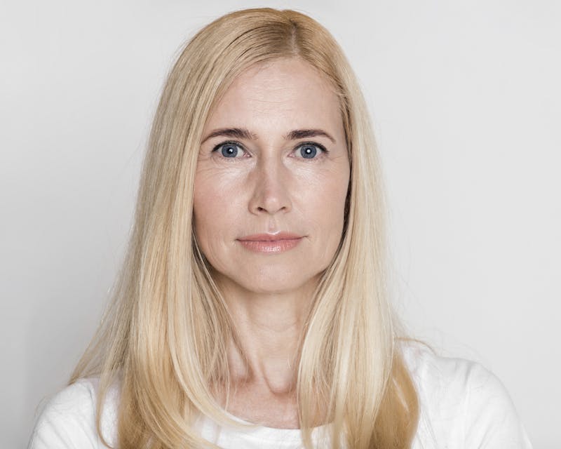 A blonde woman looking at camera