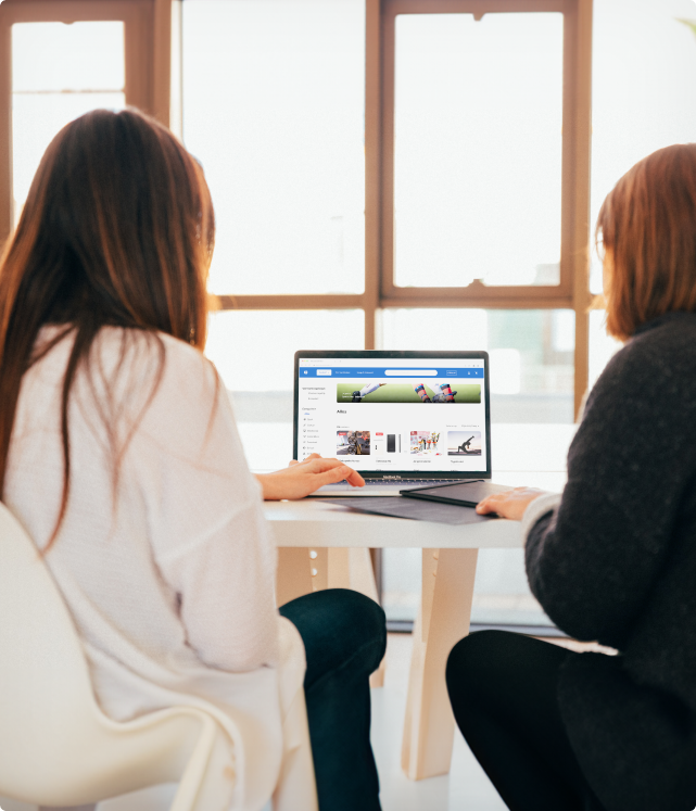 Twee personen kijken naar een laptopscherm met de demowinkel van Gemeentewinkel.