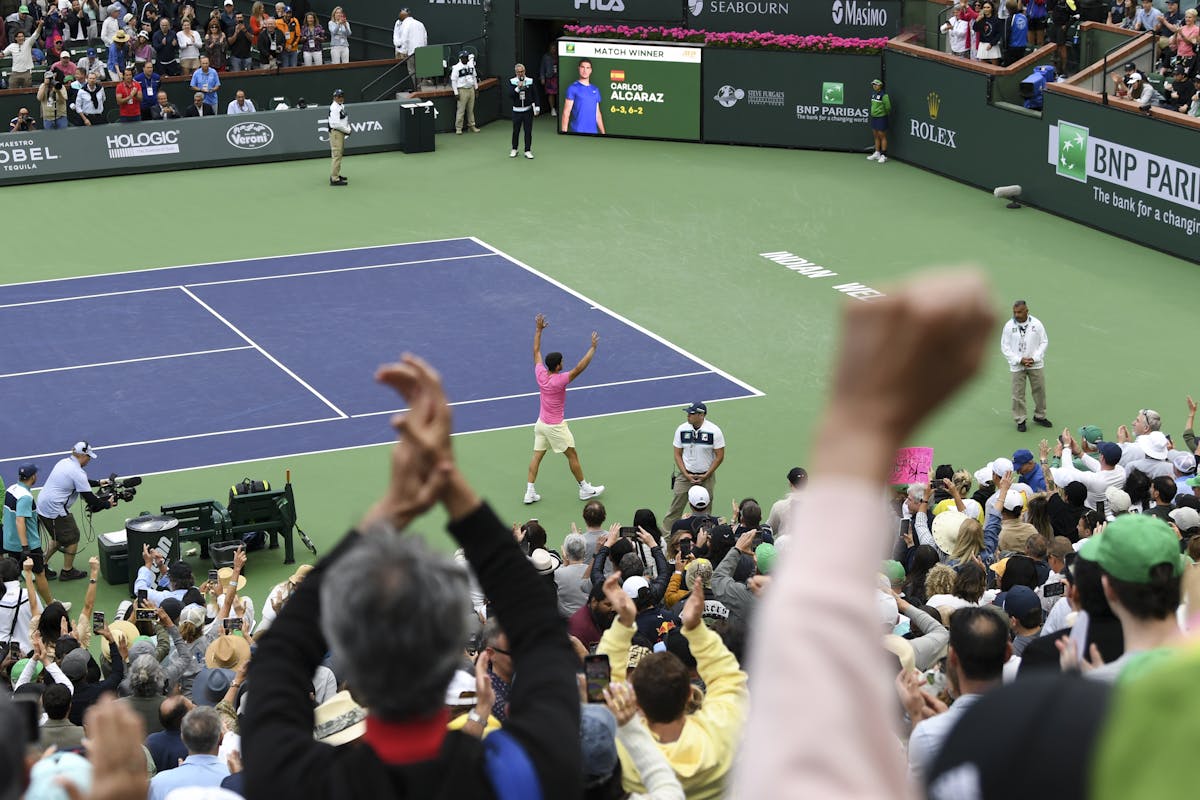 Alcaraz raise his hands on the court in celebration of his BNP Paribas Open championship win.