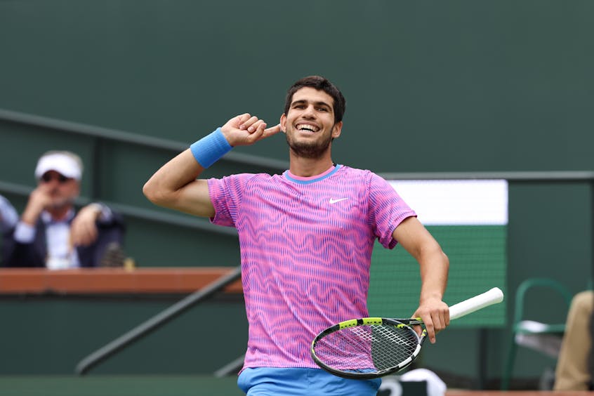 Carlos Alcaraz touches his ear to encourage cheering fans during his 2024 final against Medvedev.