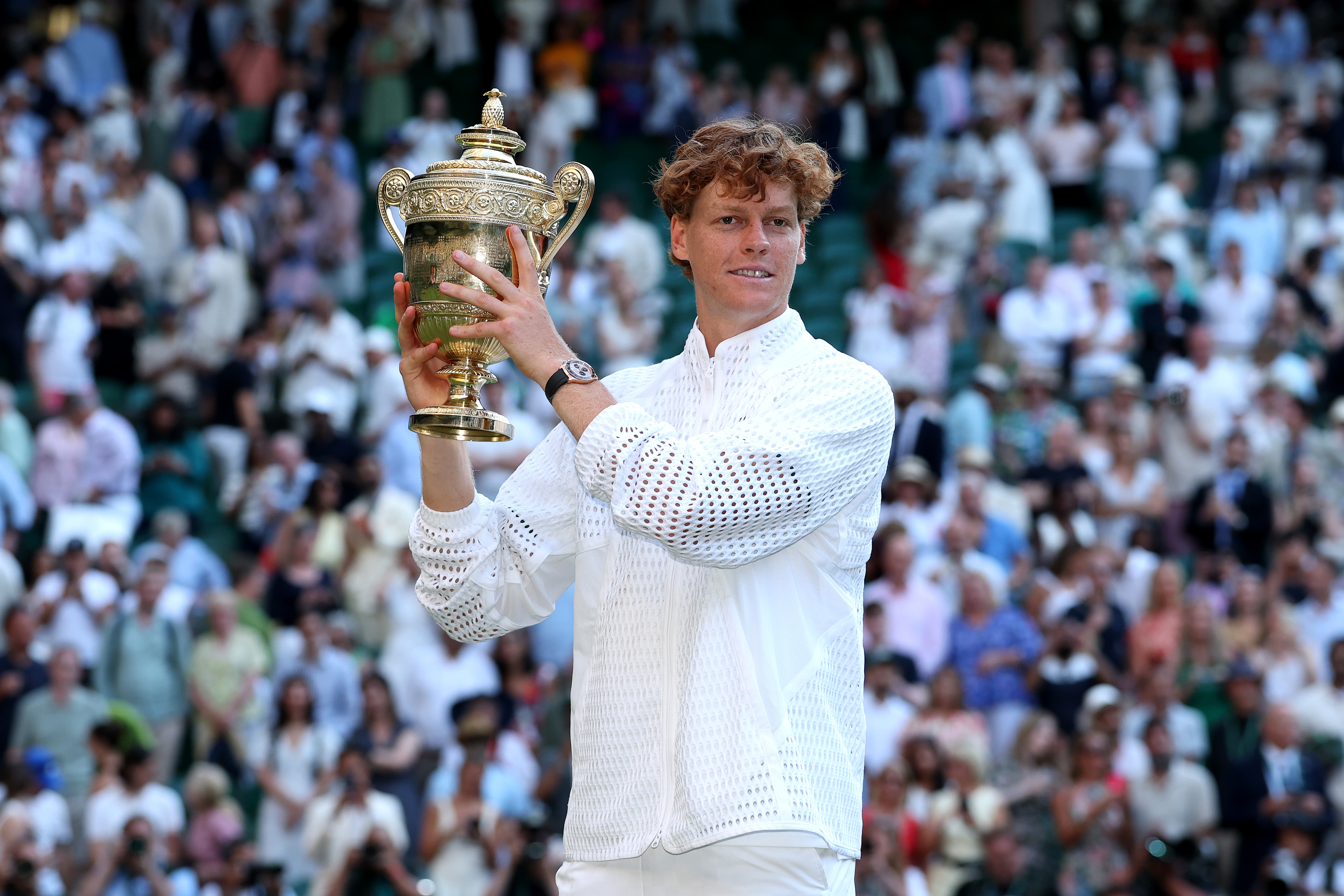 Jannik Sinner lifts the Wimbledon trophy for the second consecutive year.