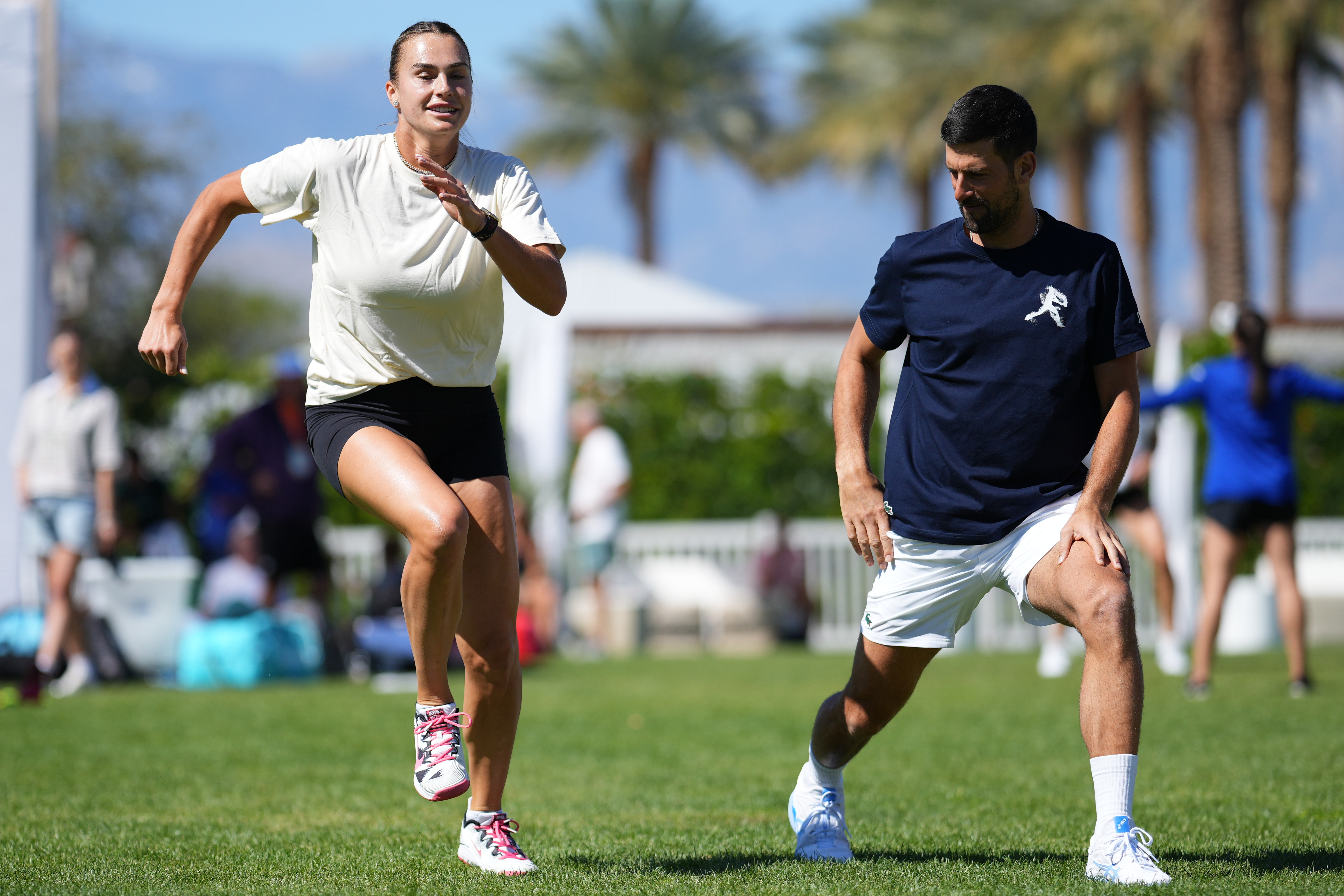Aryna Sabalenka and Novak Djokovic on the players' lawn.