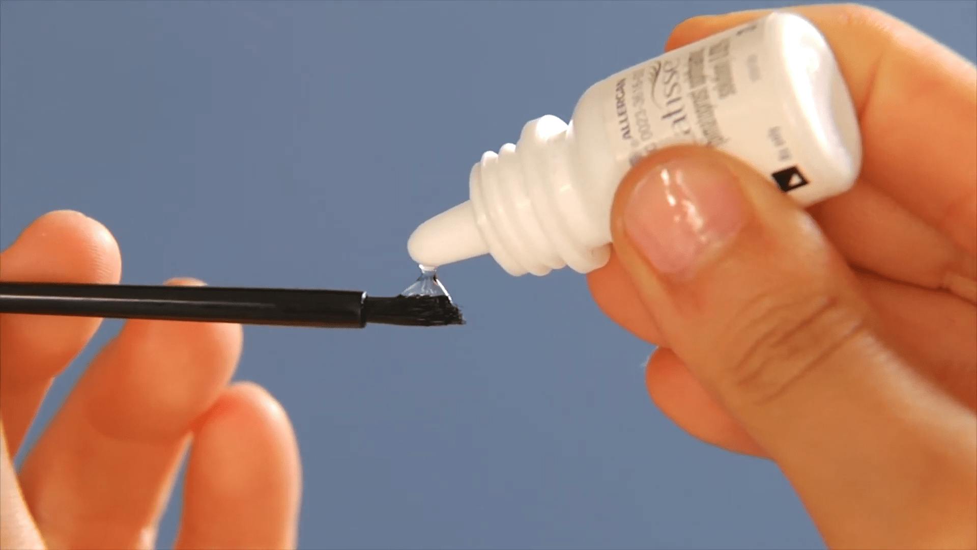 person putting Latisse on small brush