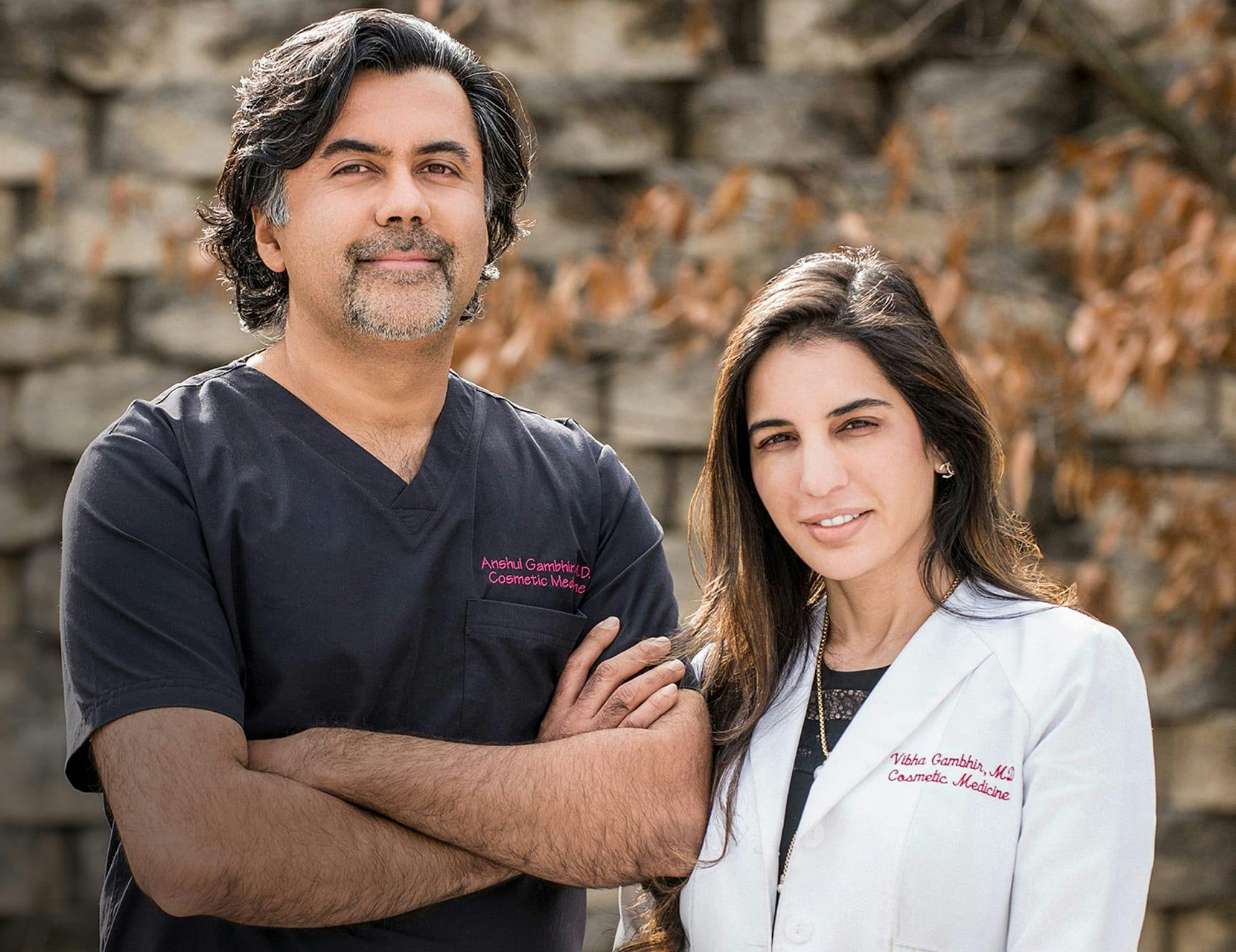 Drs. Anshul and Vibha Gambhir smiling with arms crossed