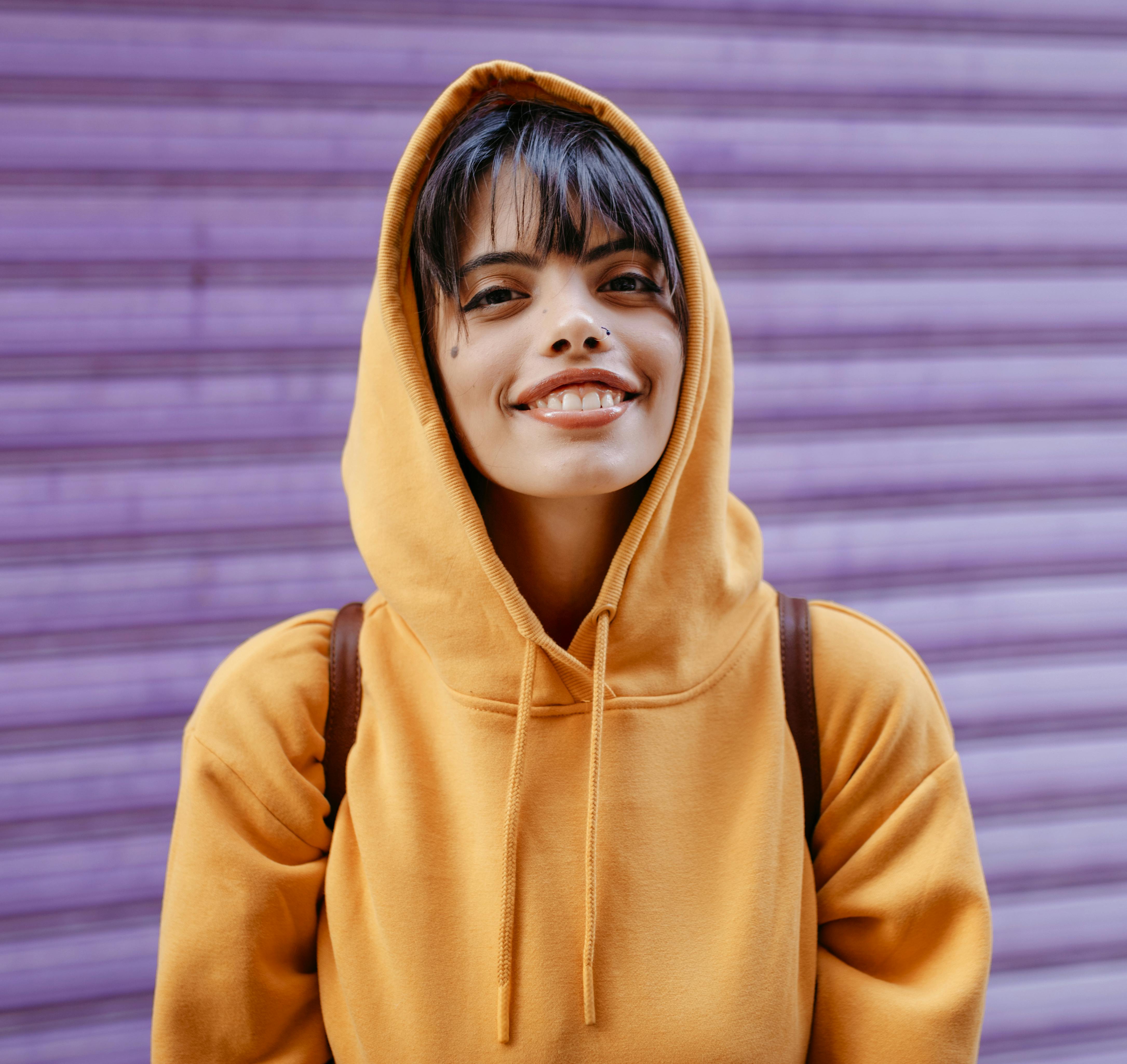Portrait of a young woman with yellow hoodie in front