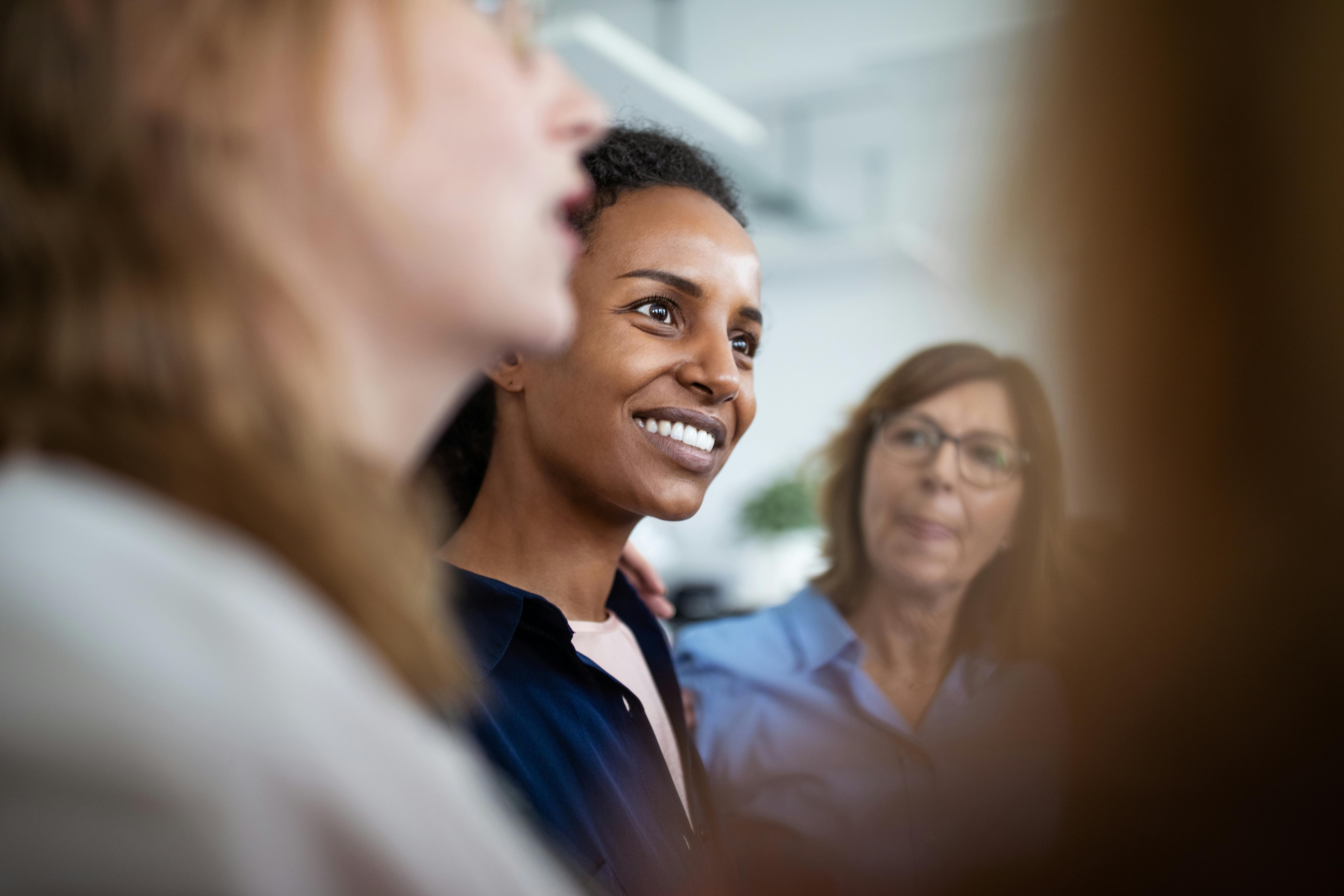 Business woman standing and talking with colleagues in office