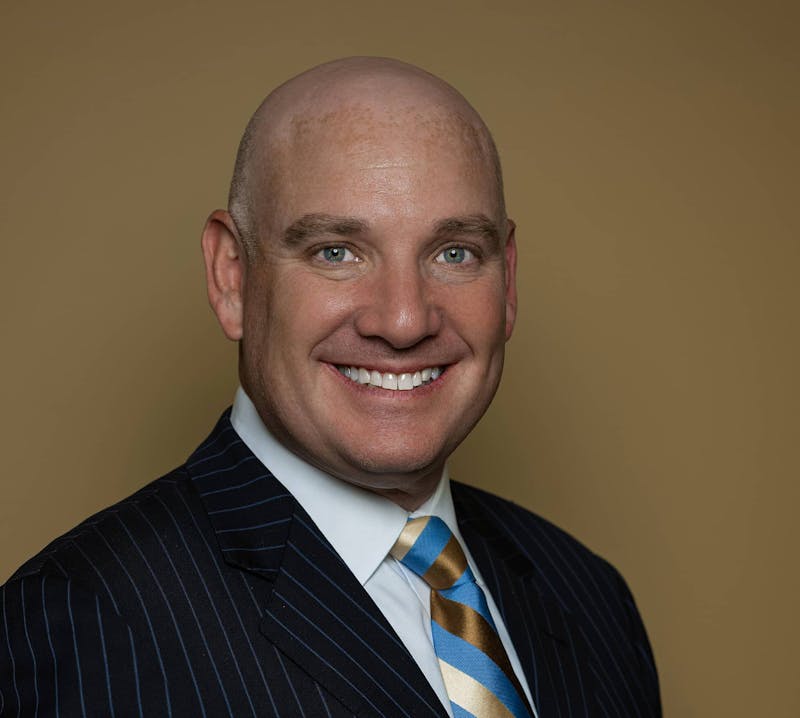 Dr. Menkowitz smiling in suit