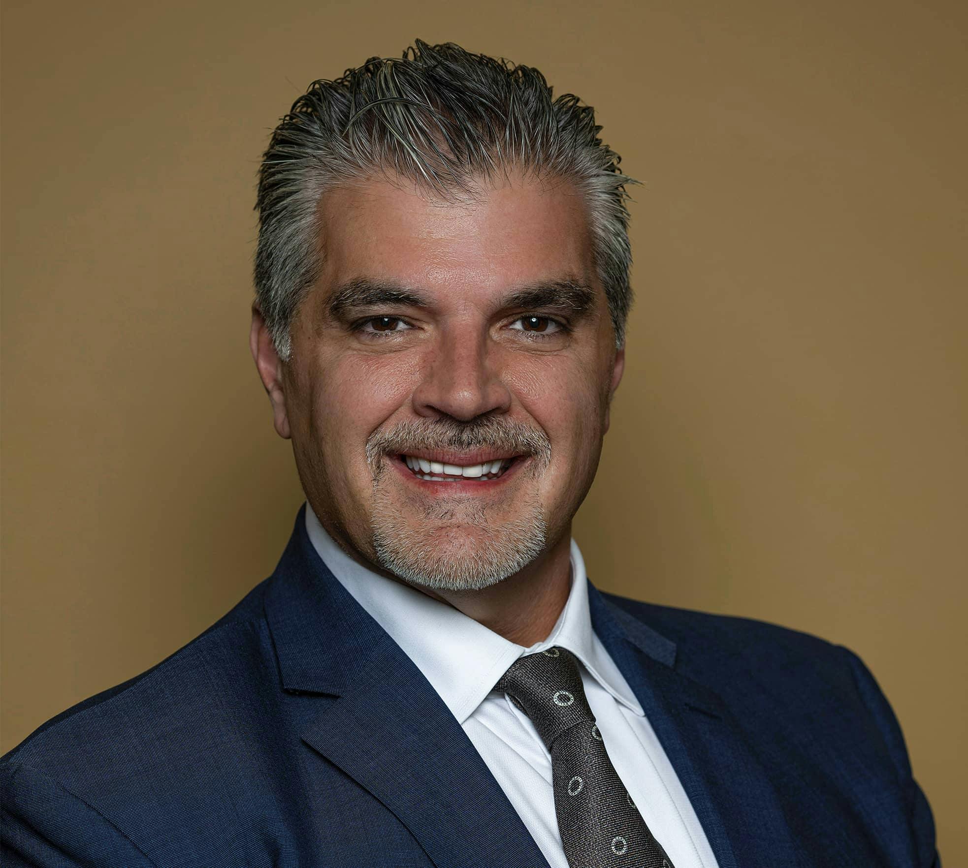 Dr. Steve Paragioudakis smiling in suit