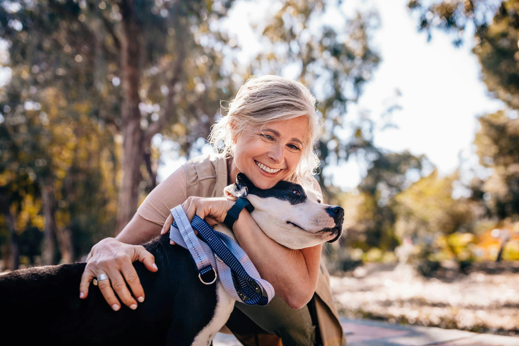 Woman smiling and hugging dog