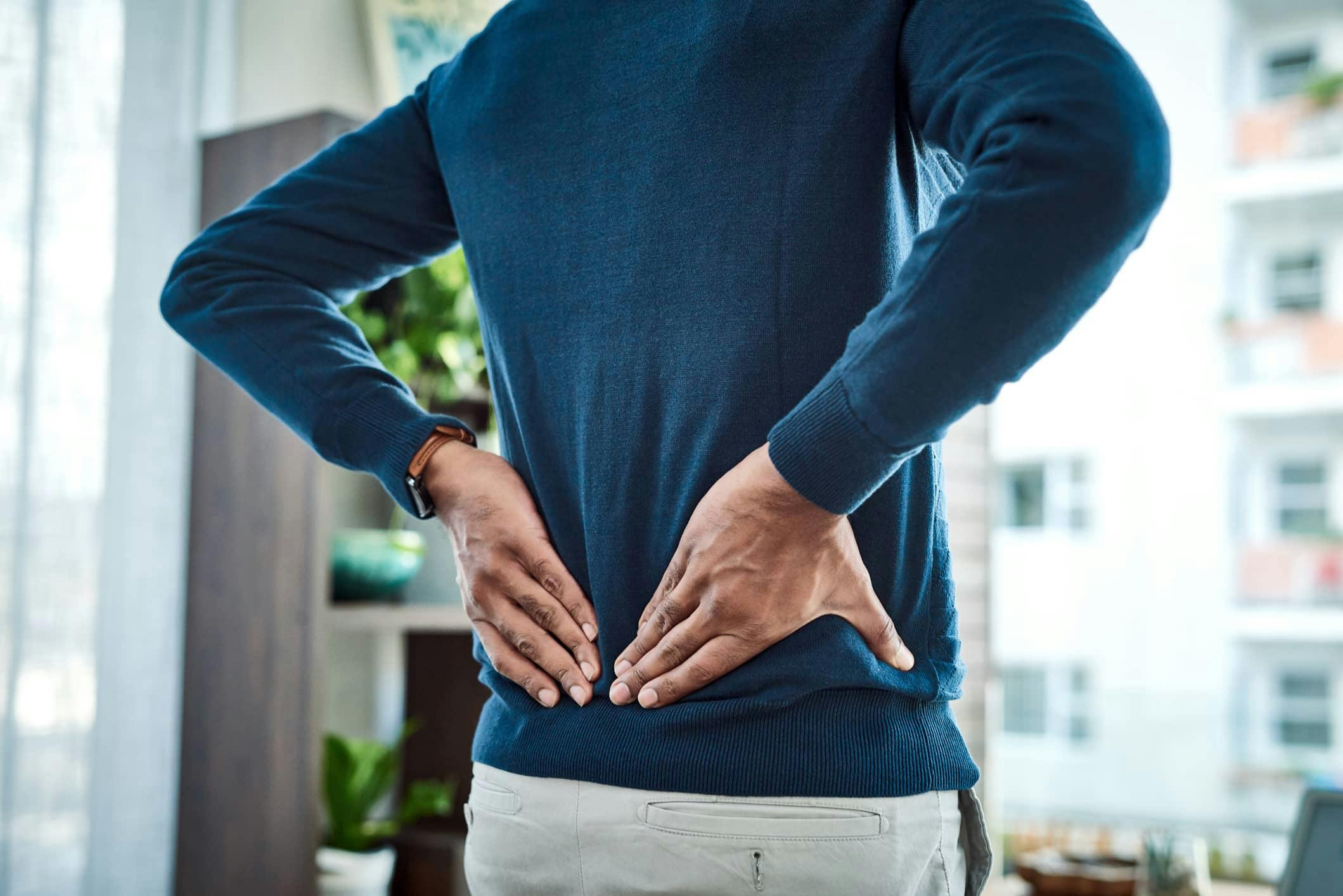 Man holding lower back in pain