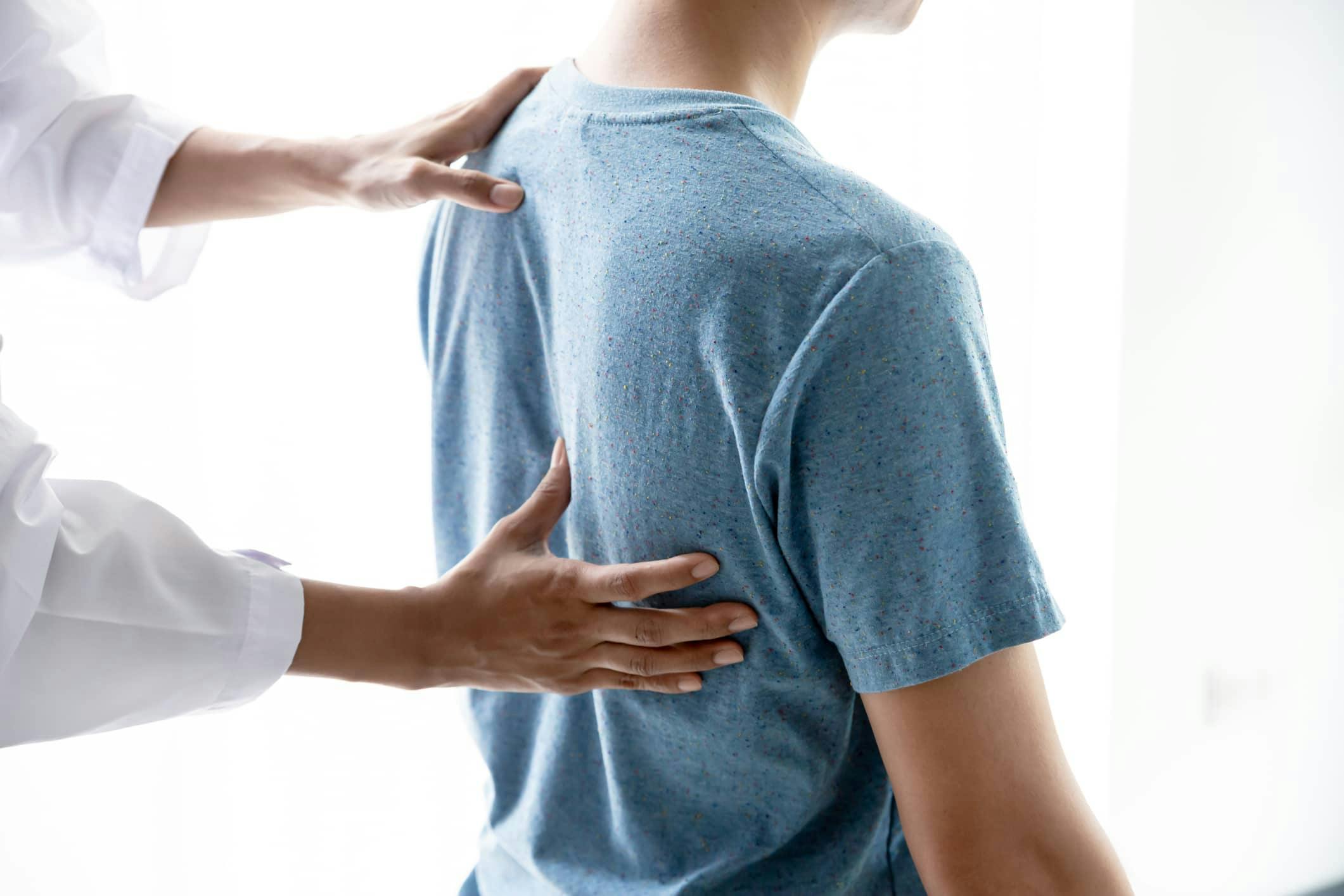 Doctor examining patient's back and spine