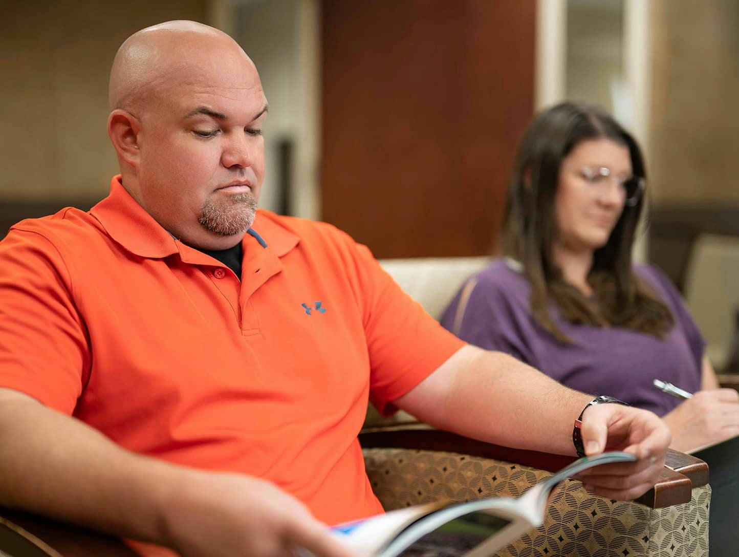 Bald man reading magezine in waiting room