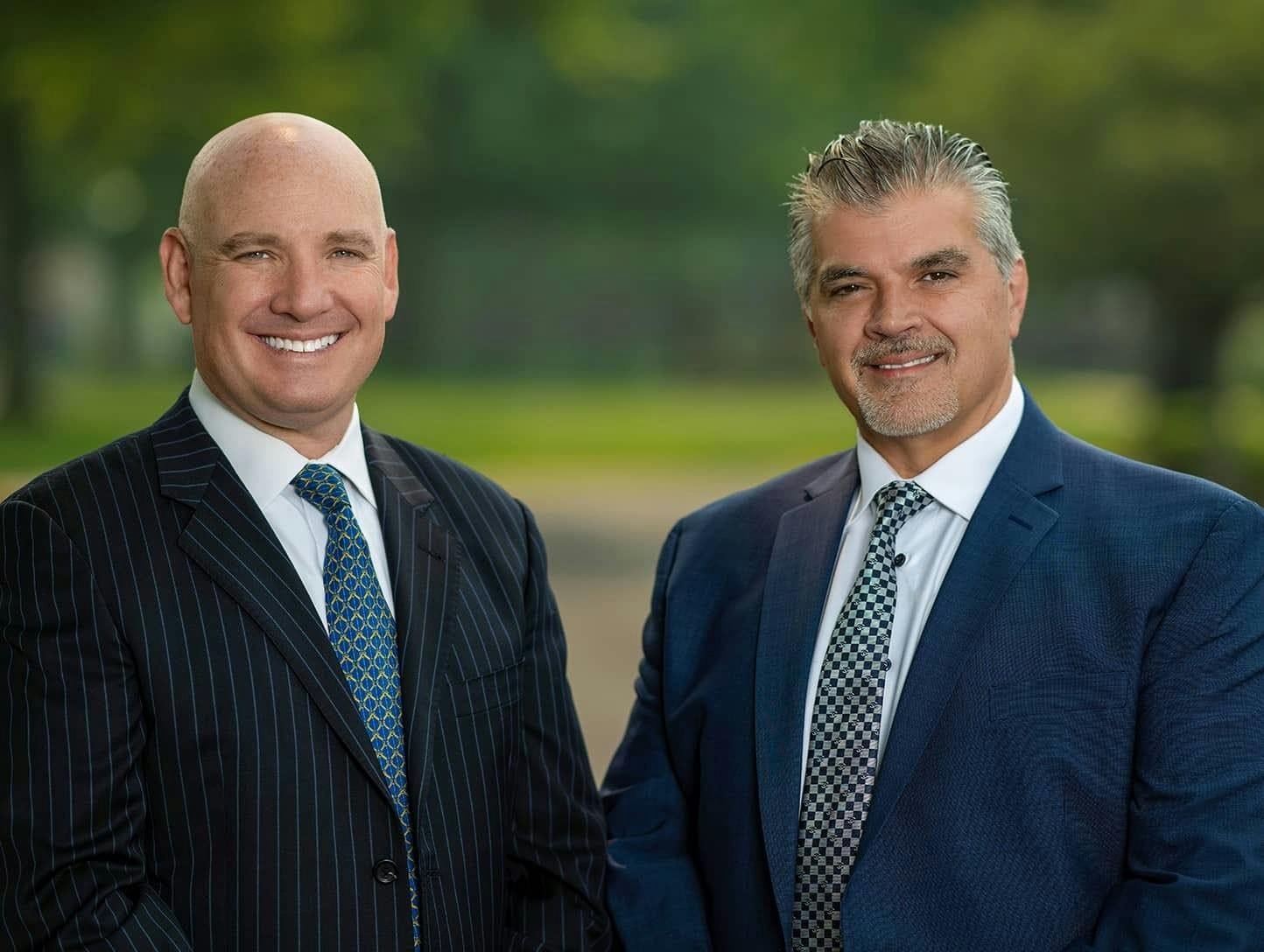 Dr. Steve Paragioudakis and Dr. Marc S. Menkowitz smiling and wearing suits