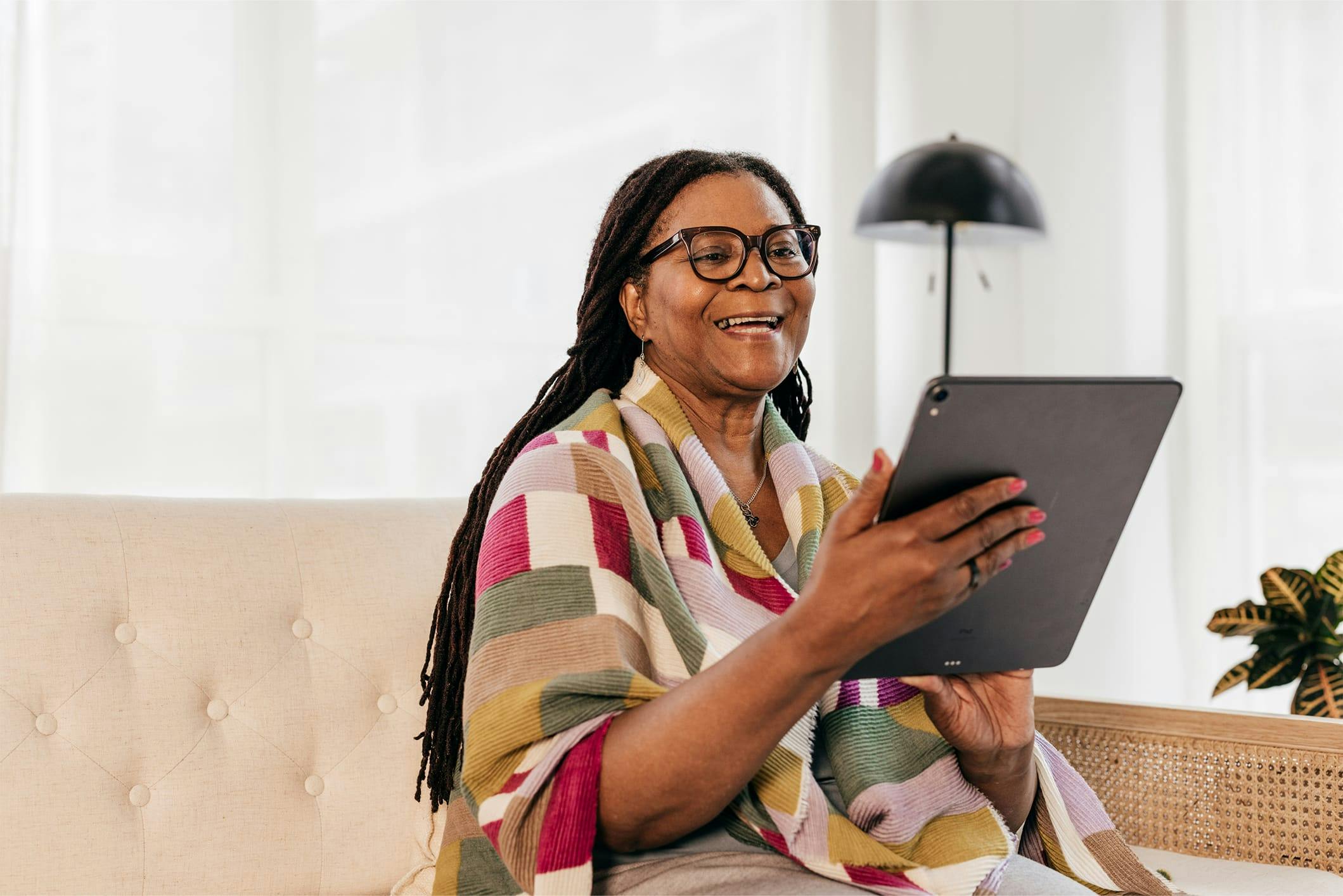 Older woman smiling and looking at tablet