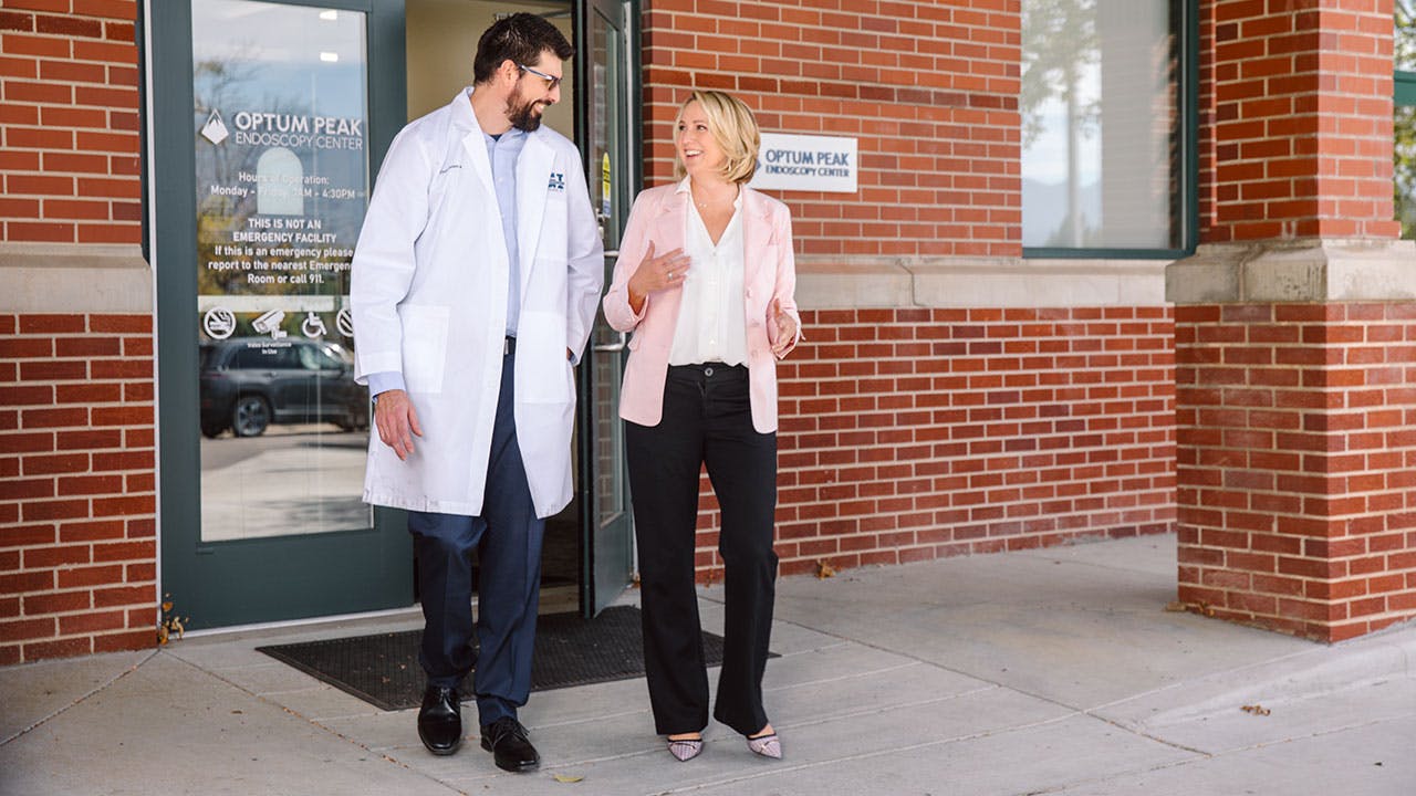 Doctor walking with patient outside both are smiling