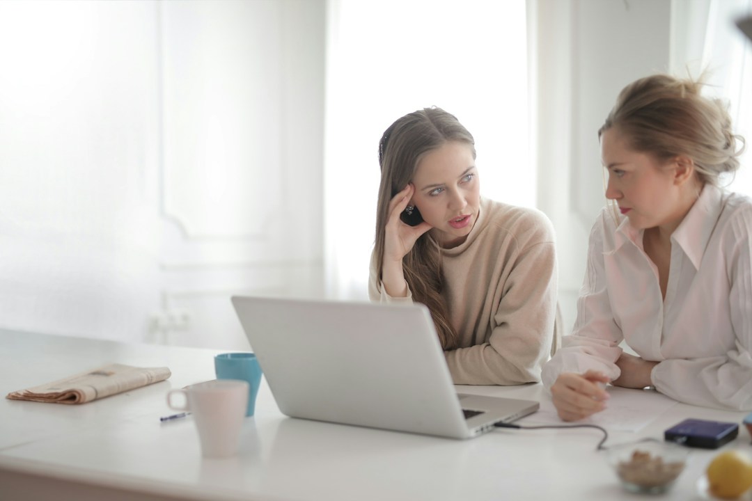 Two women in front of a computer talking