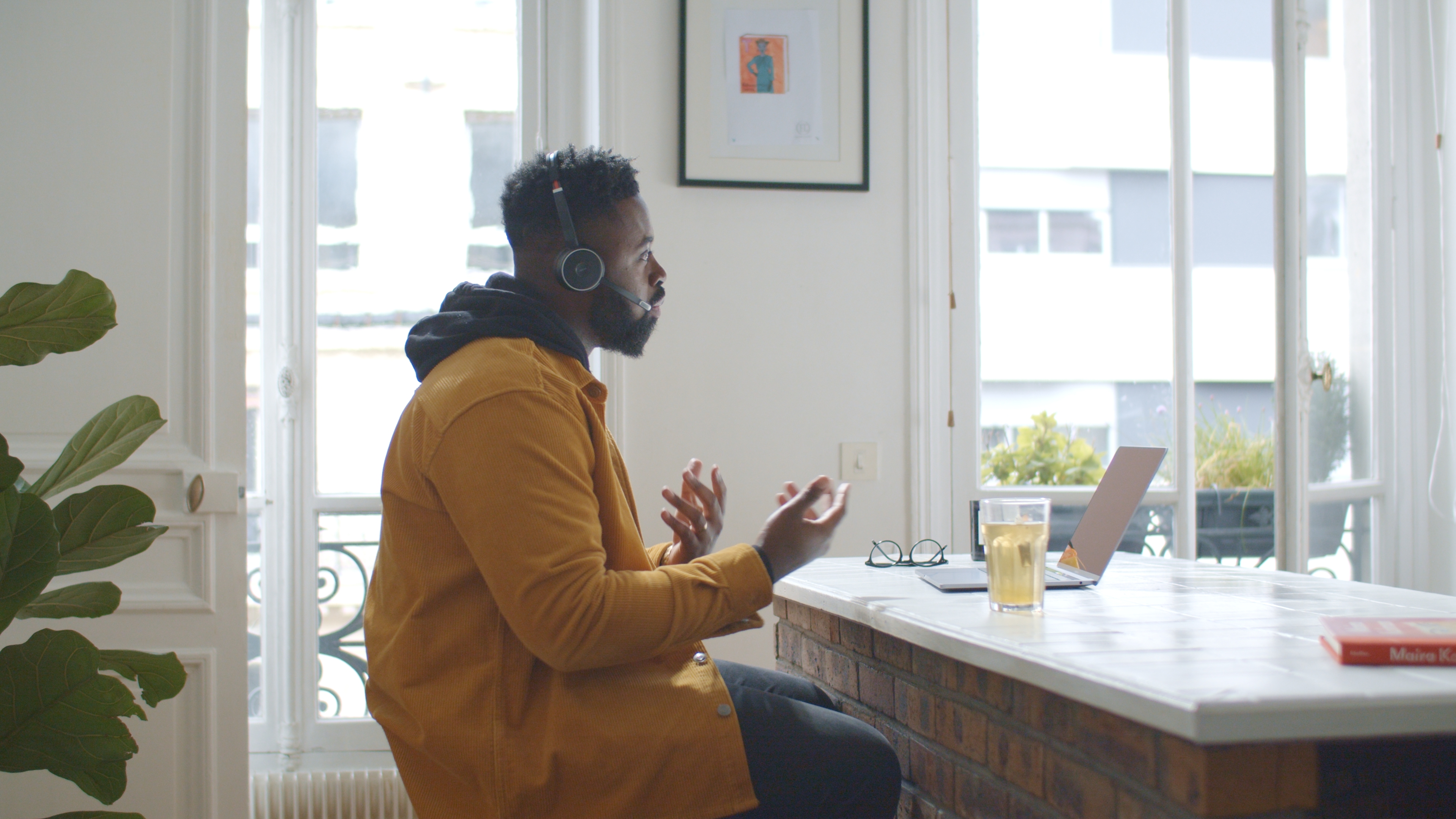 Man wearing headphones and yellow shirt making a sales call