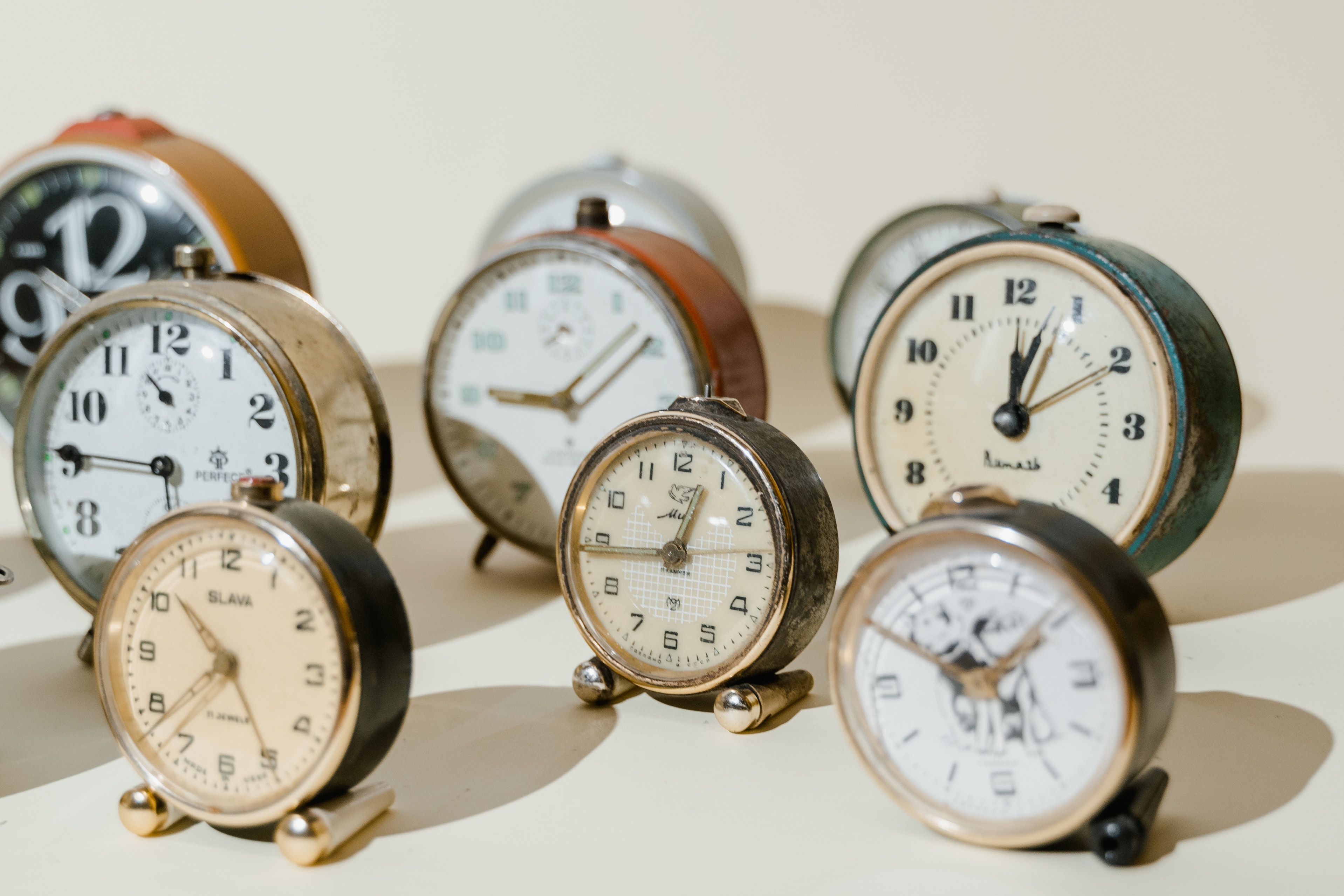 small clocks arranged on a beige background