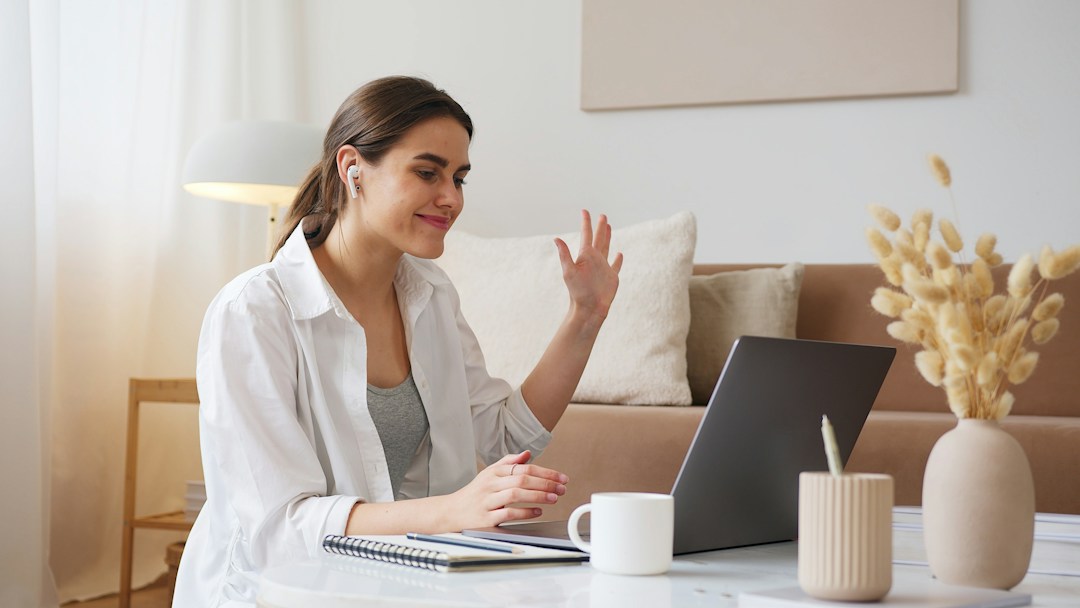 Woman waving to computer screen