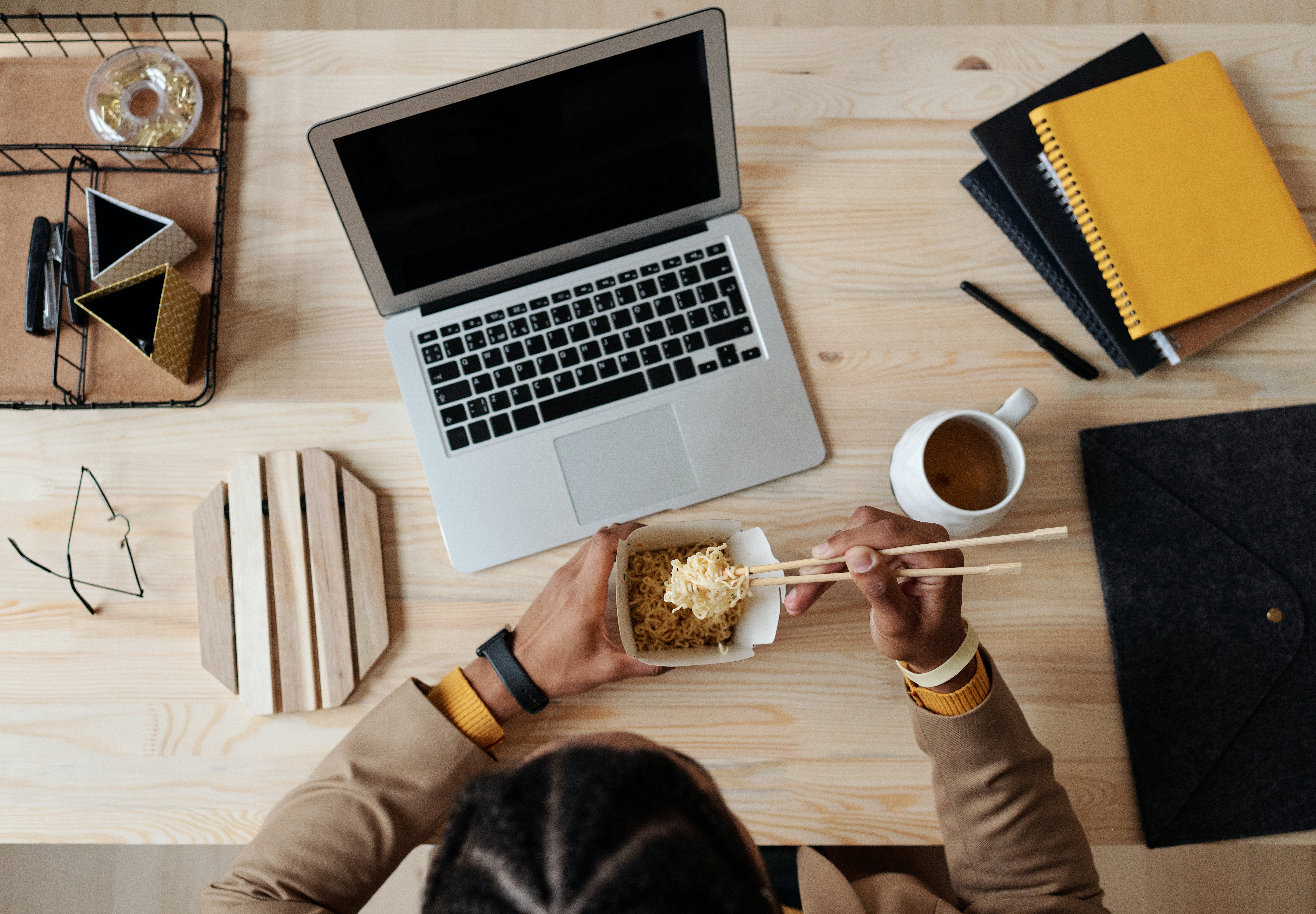 breaking meeting etiquette by eating noodles in front of a computer