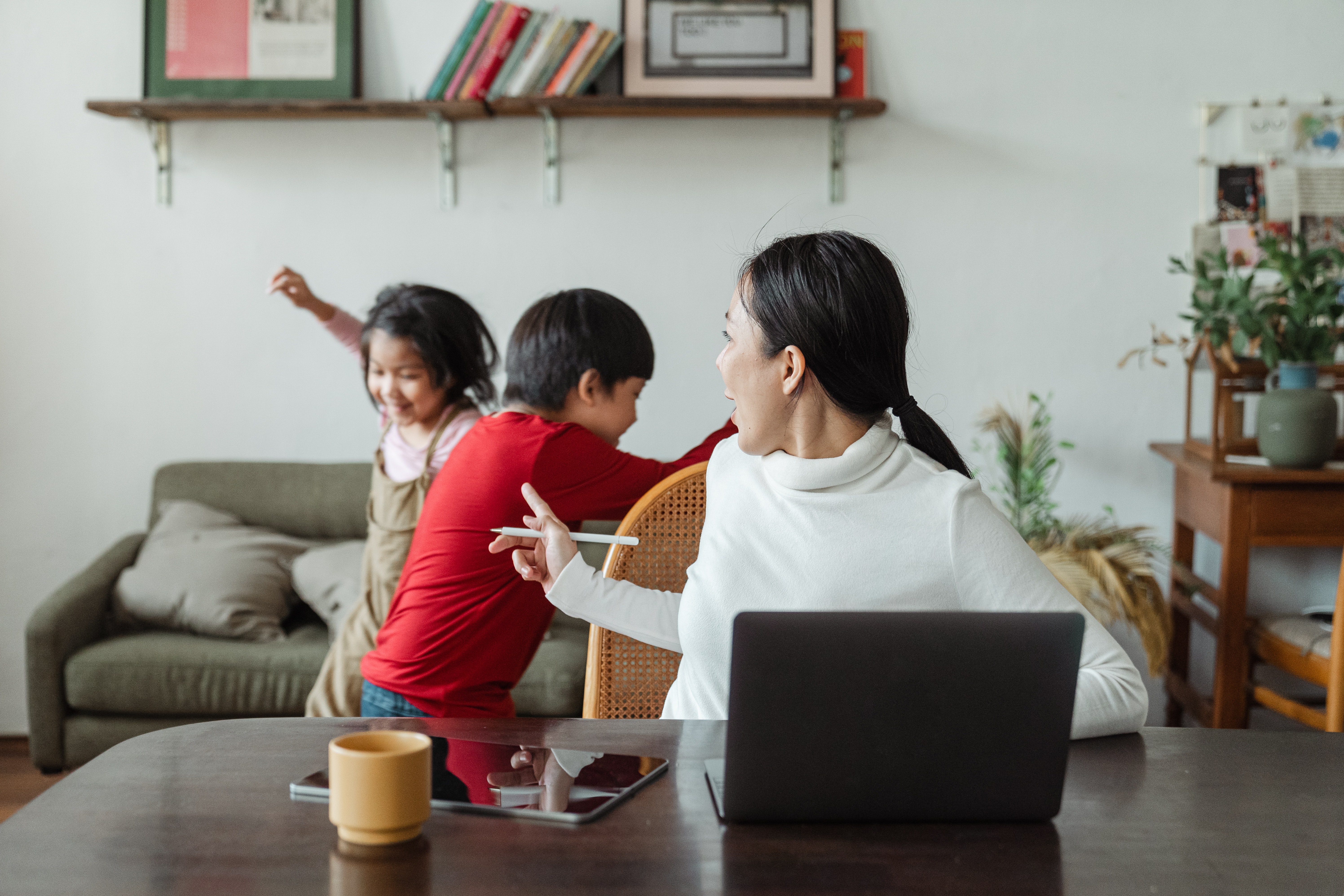 two children running while mother tries to work from home