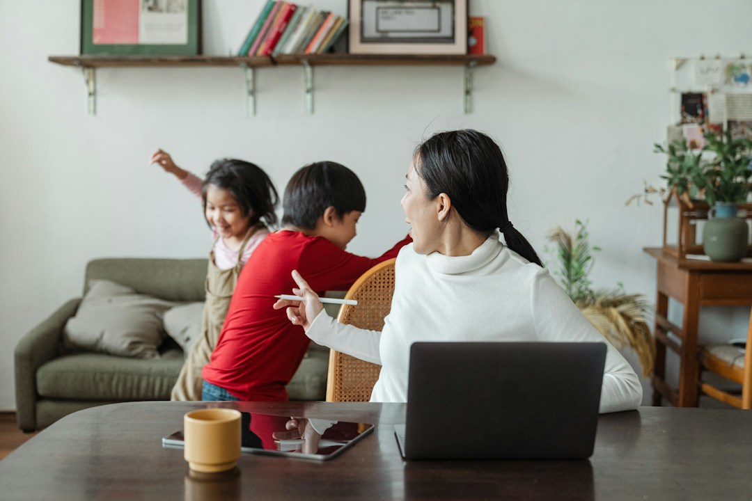 two children running while mother tries to work from home