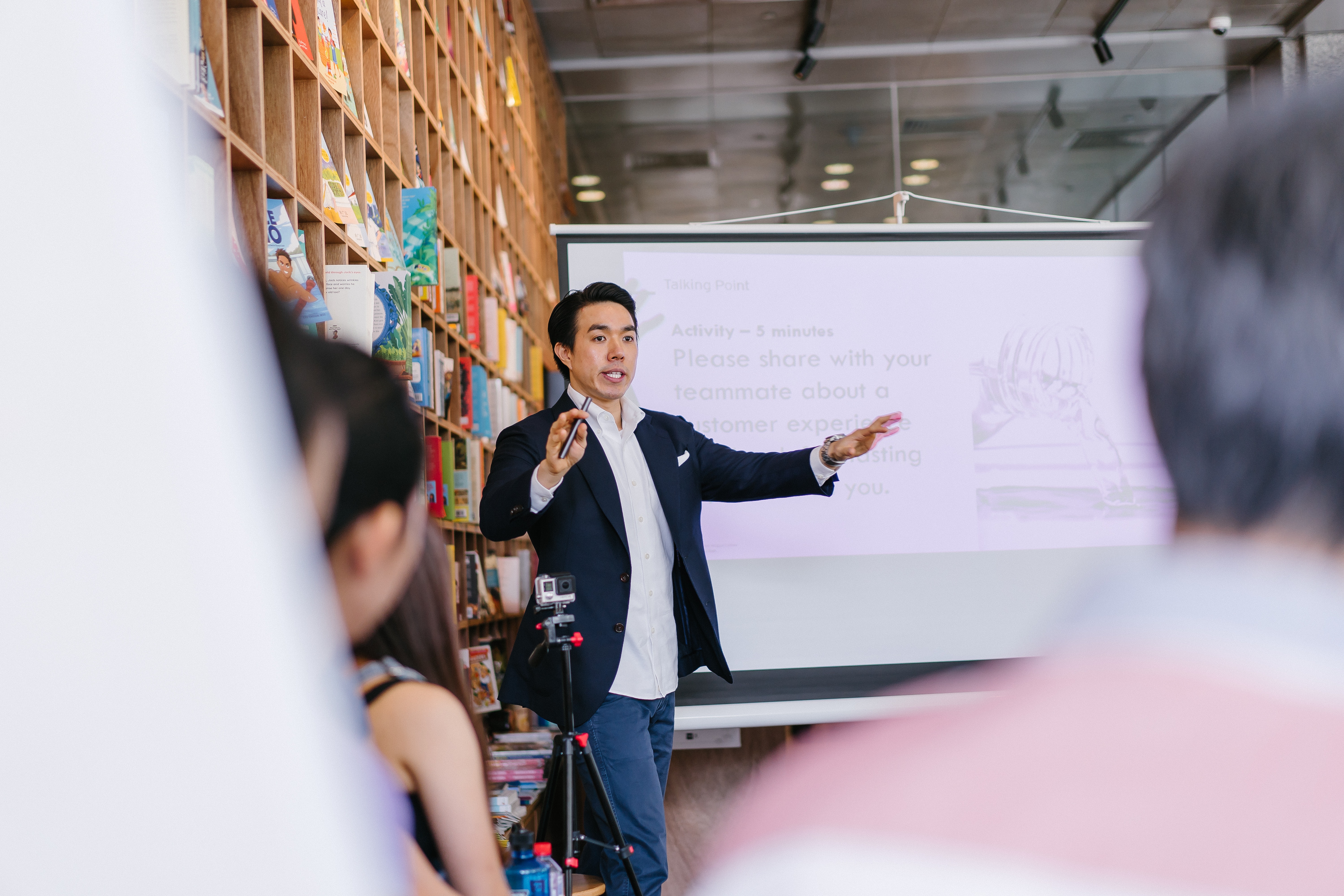 man wearing suit jacket and jeans speaking in public