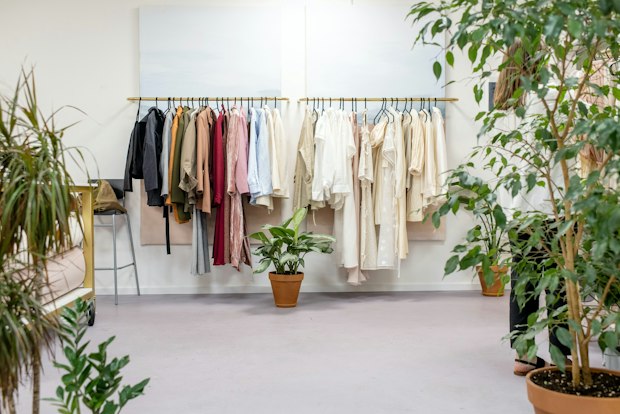 clothes hanging up in a showroom with plants