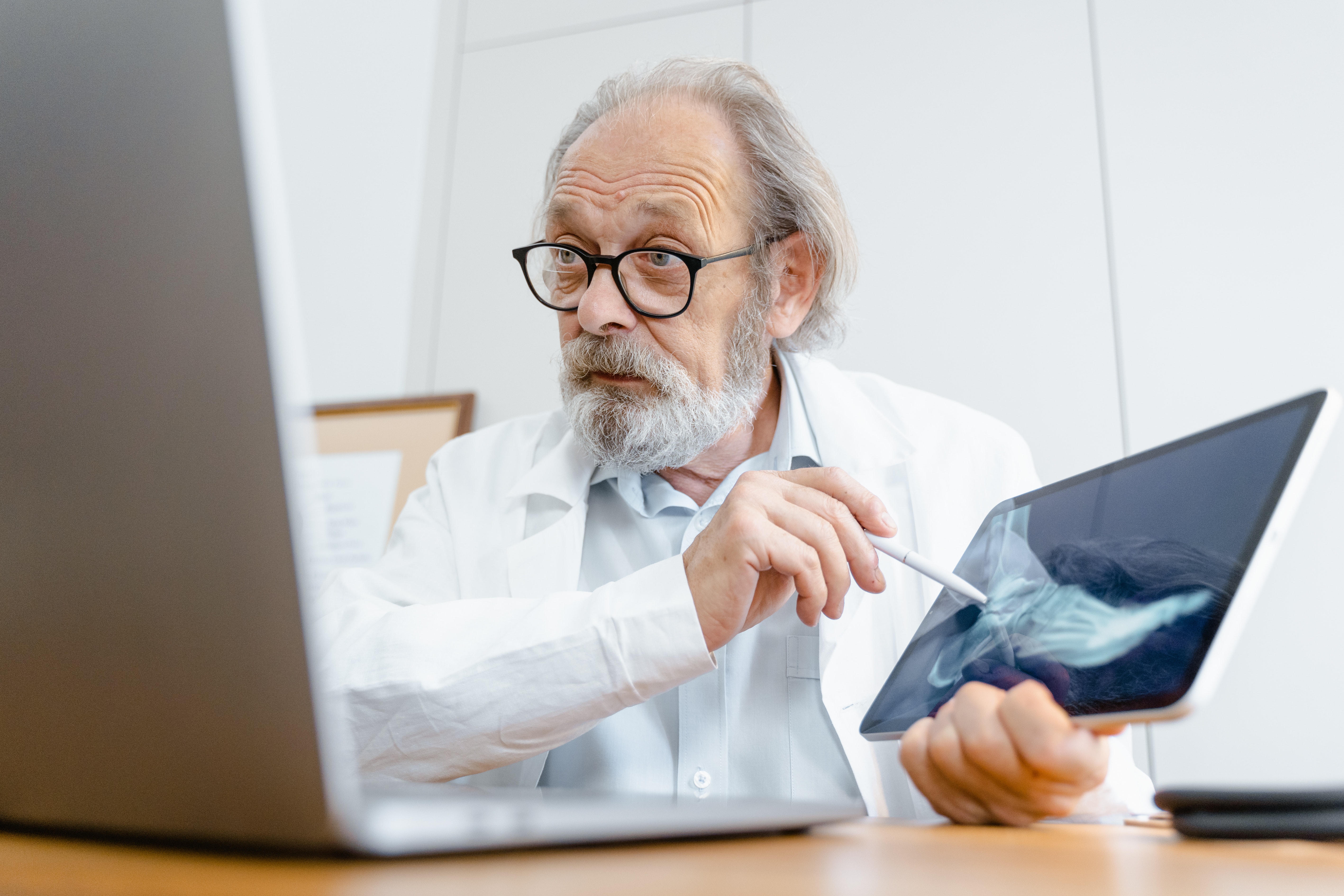 older man doctor showing an xray of a foot to a video camera